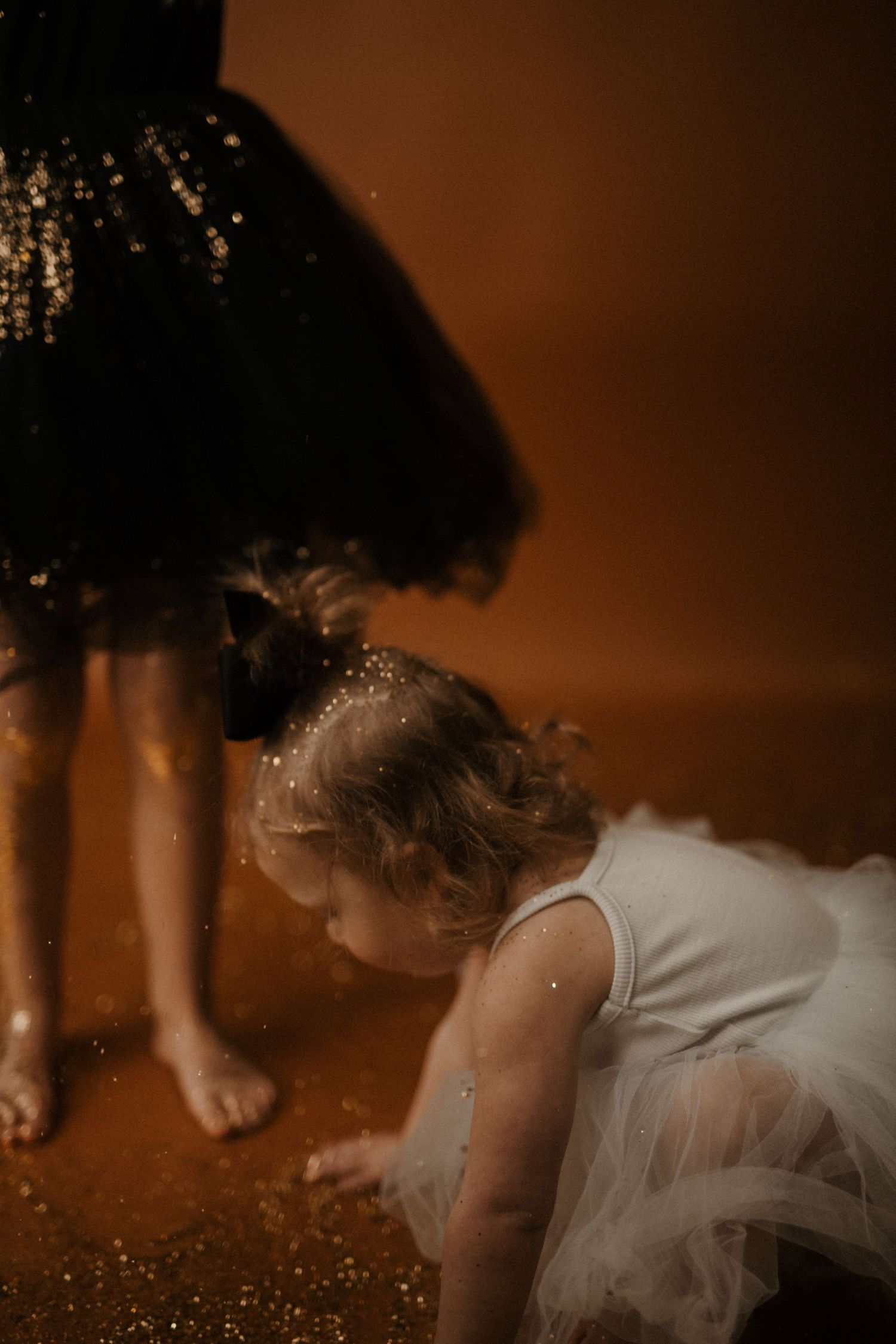 A sequence of photos showing a person in a white dress lying down on a surface with sparkly glitter elements.