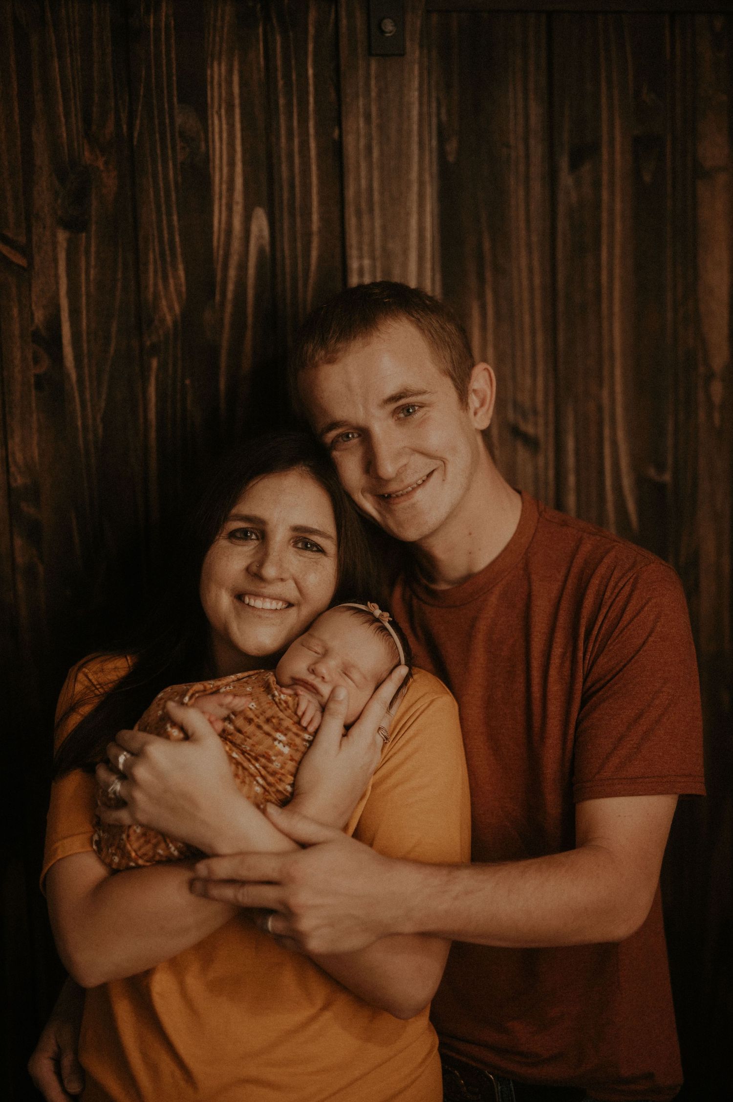 A series of warm-toned photos showing an intimate family moment with embraces against a dark wooden background.