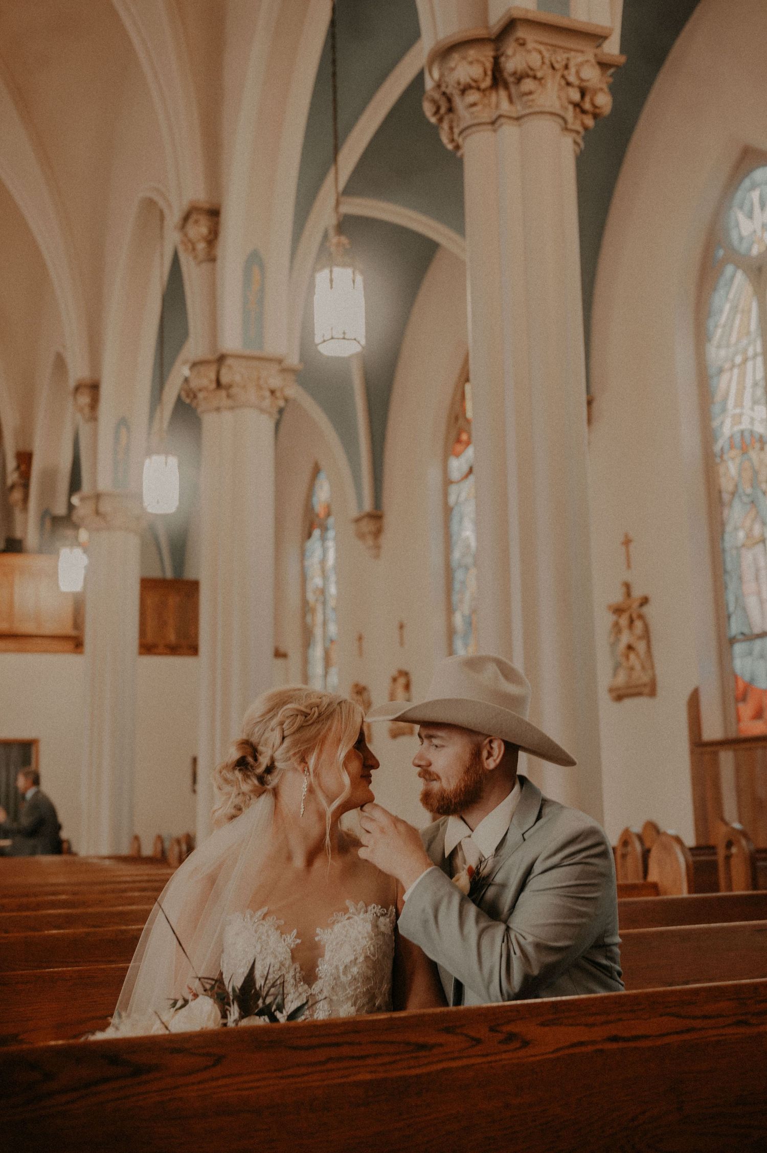 A romantic moment captured between a couple in a traditional church setting with gothic architectural details.
