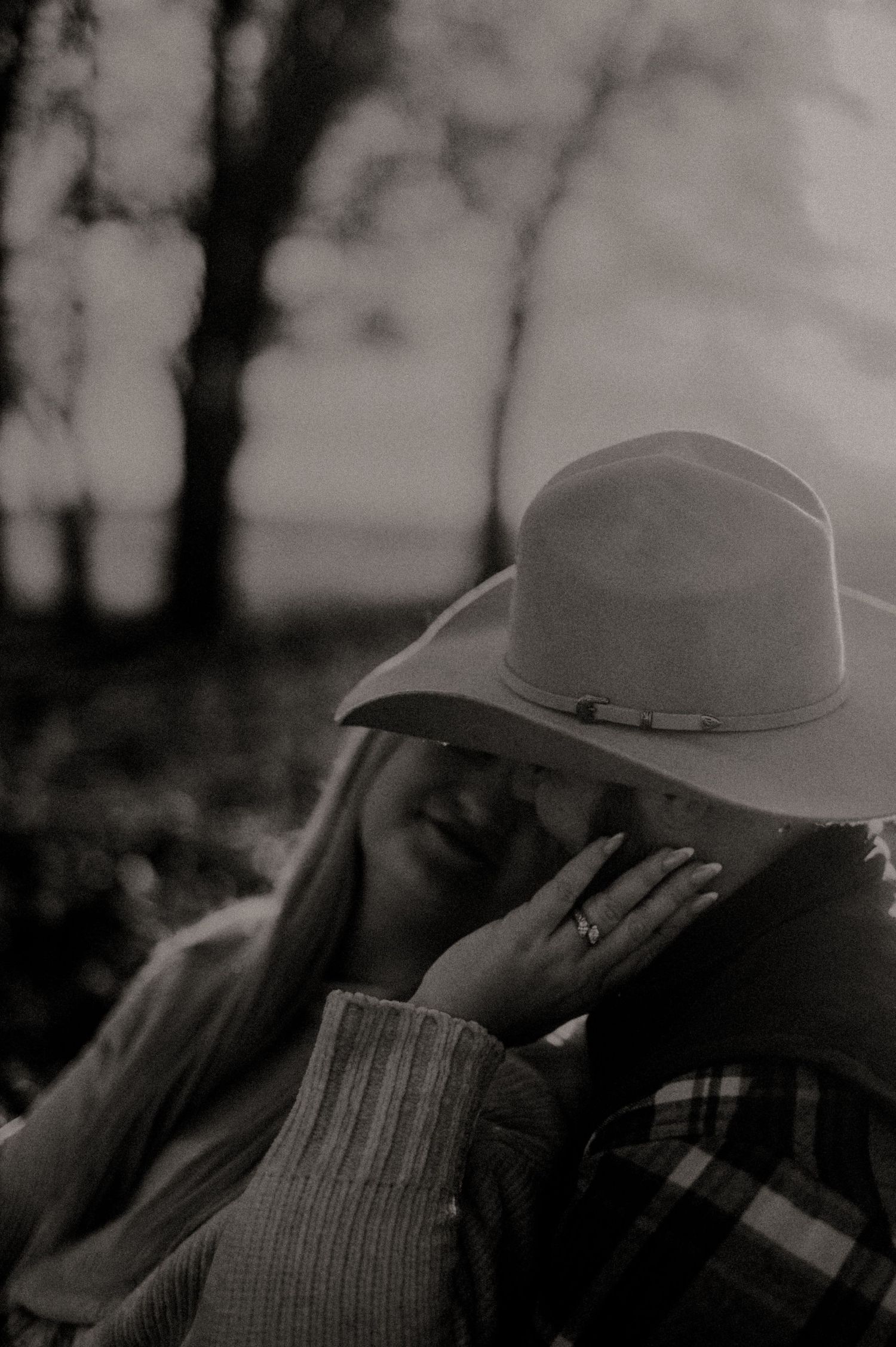 A close-up silhouette of someone wearing a cowboy hat against a moody dark background.