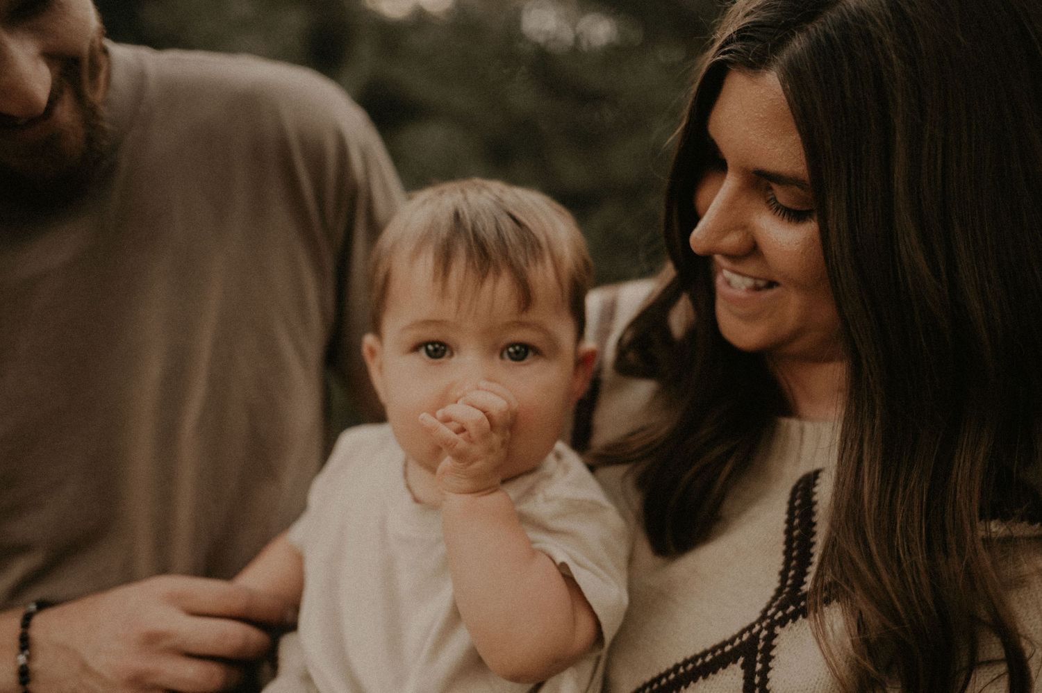 Candid family moments captured in warm sepia tones showing tender interactions.