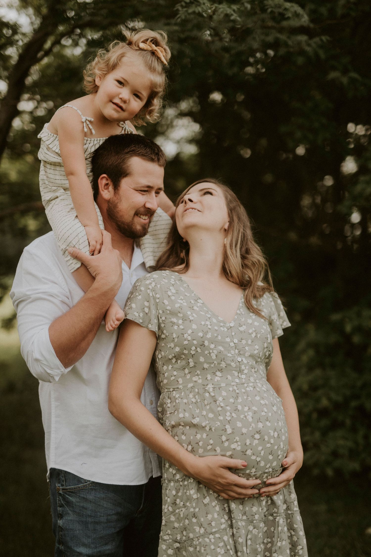 A couple shares tender moments outdoors in a series of romantic maternity photos at sunset.