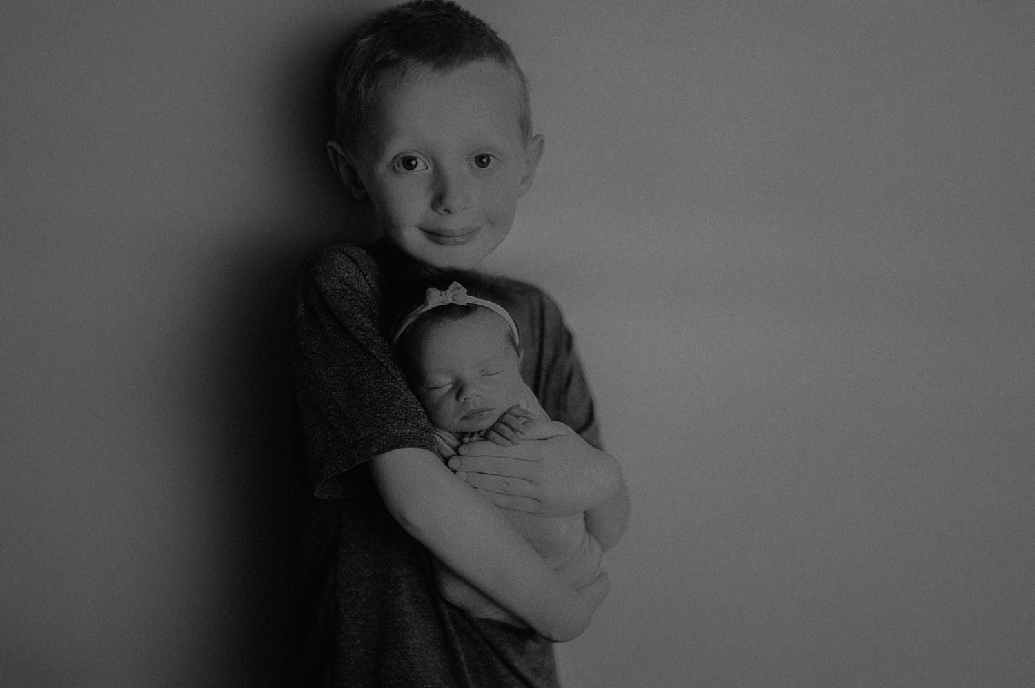 Black and white portrait series of siblings showing natural expressions and connection.