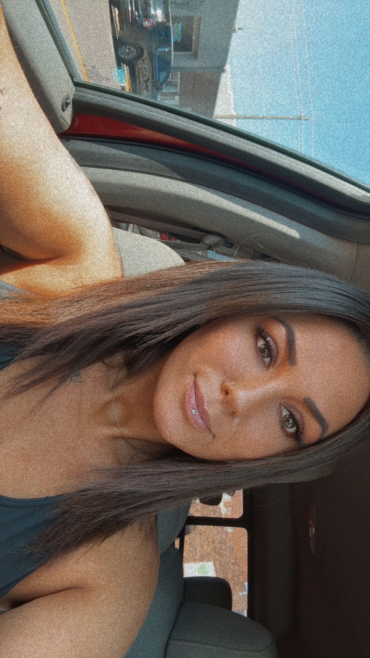 Car selfie with natural lighting and blue sky background.