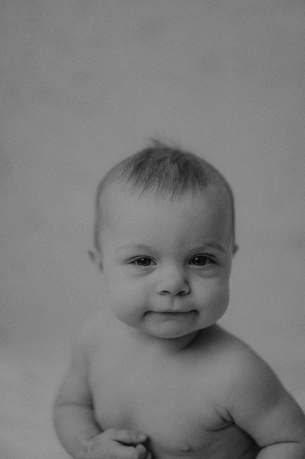 Black and white close-up portraits of an infant showing various sweet expressions.