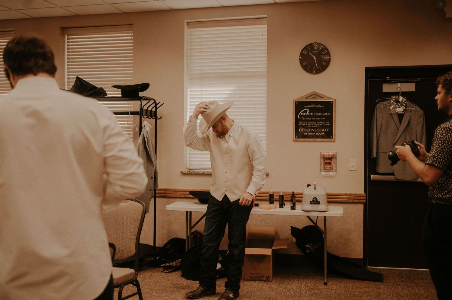 Multiple candid shots in a beige-toned room showing casual interactions and movement.
