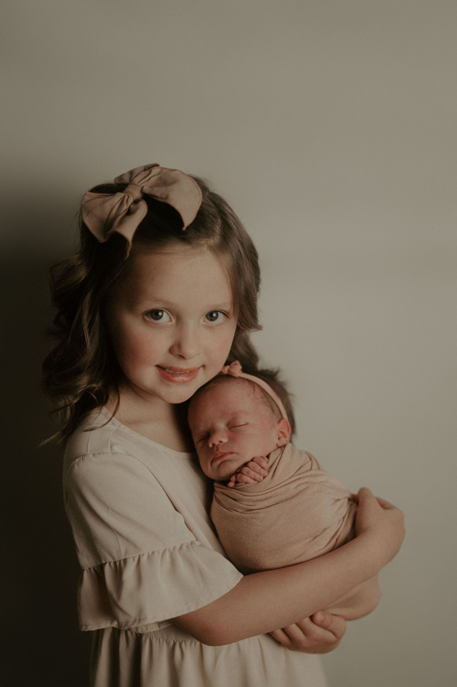 Sweet portrait of siblings in neutral tones sharing a tender moment together.