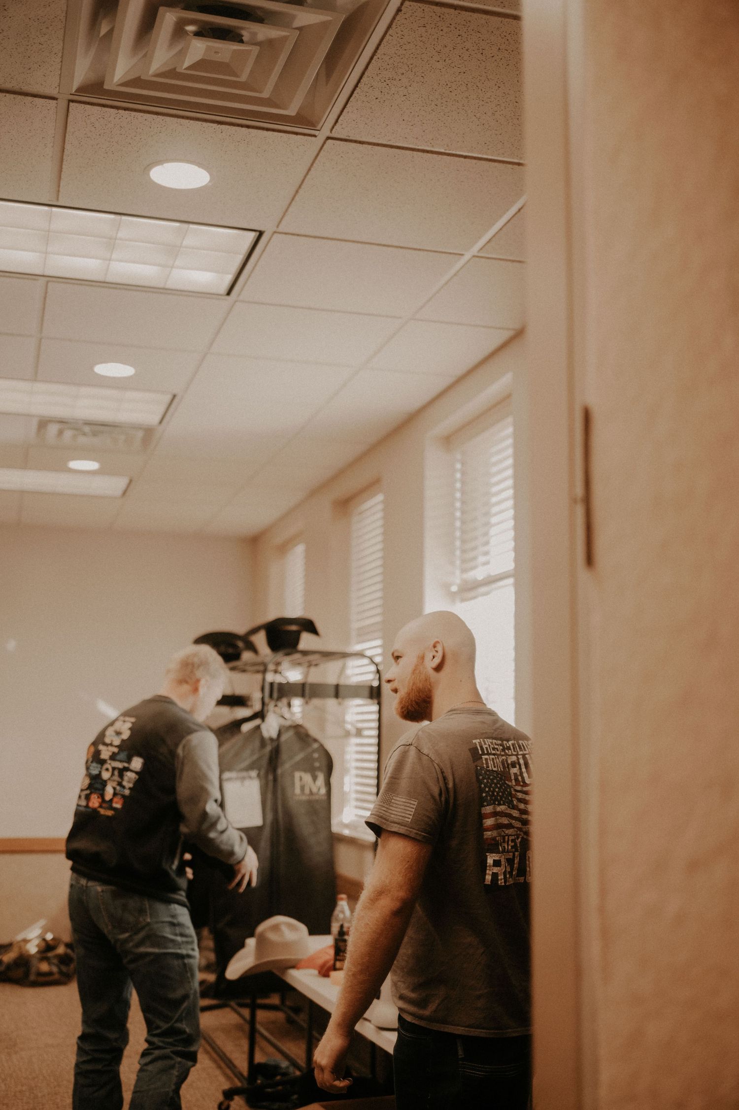 Group gathered in an indoor space with fluorescent lighting and white walls.