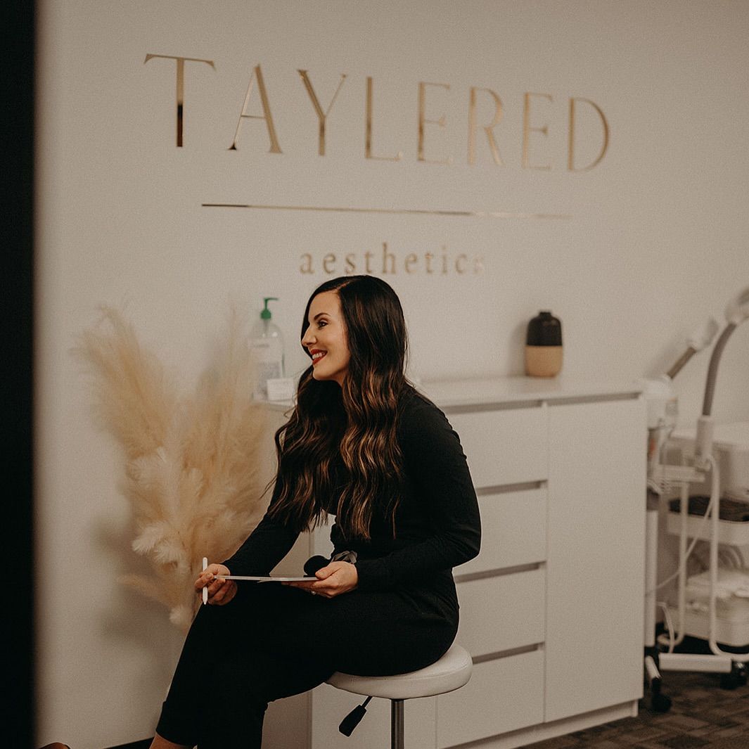 Interior view of a modern aesthetic salon with minimal decor and text on the wall.