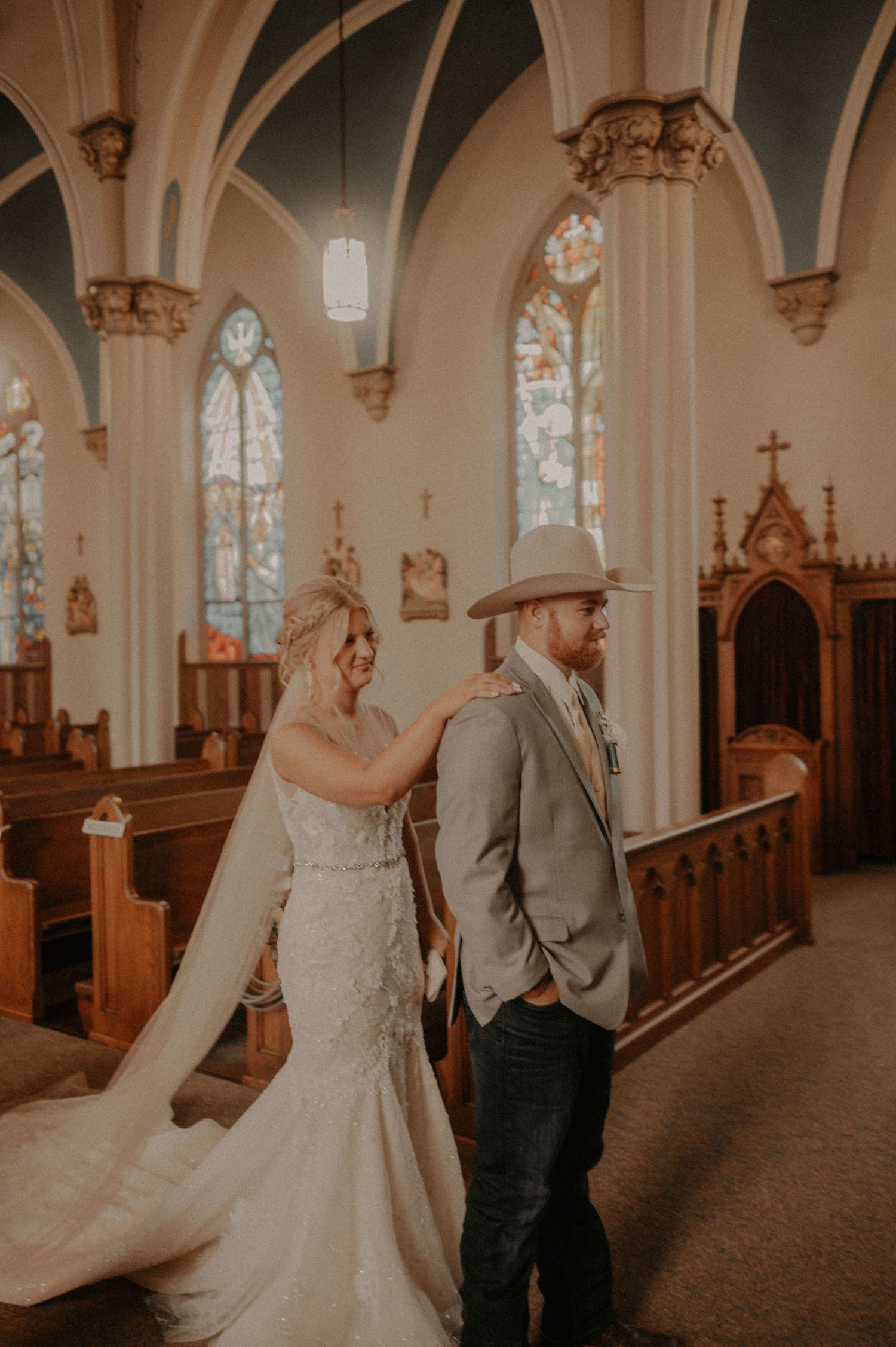 Wedding couple sharing a first look moment in a beautiful historic church with gothic architectural details.