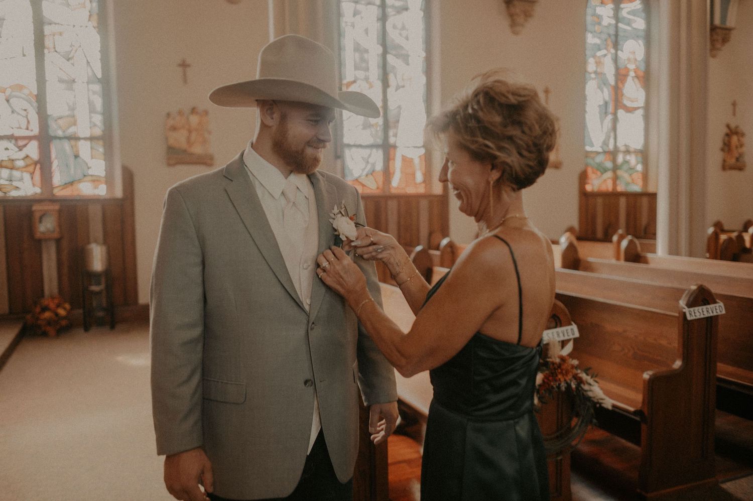 Bride and groom share intimate moments during their wedding ceremony in a sunlit church.