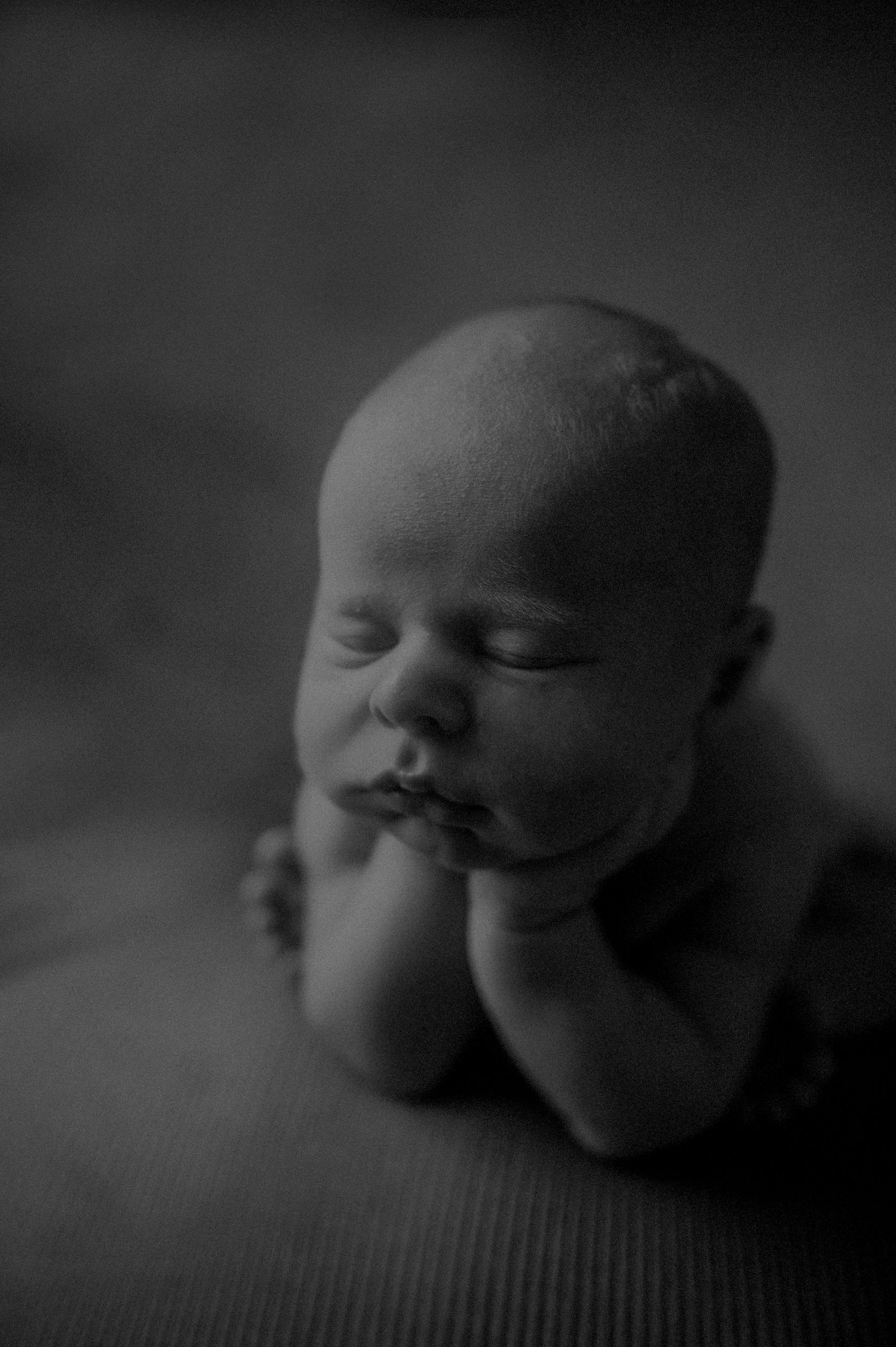 A series of black and white close-up photographs showing a sleeping baby's face from different angles.