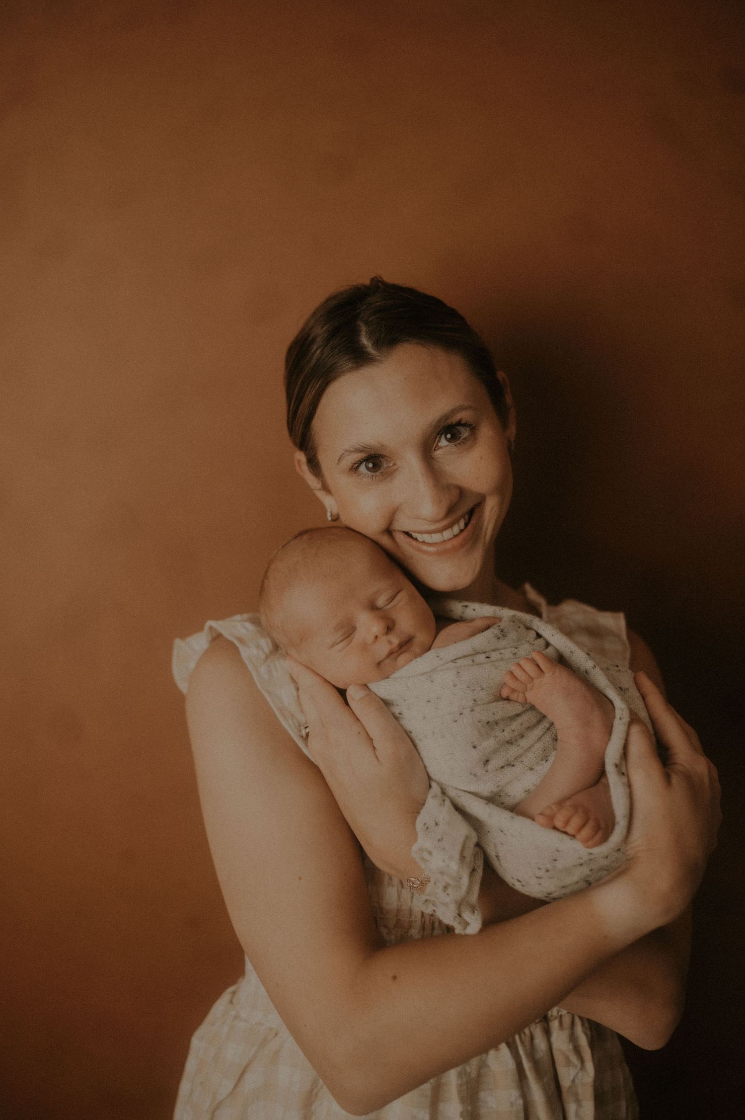 Intimate sepia-toned portrait showing tender moments between parent and child.