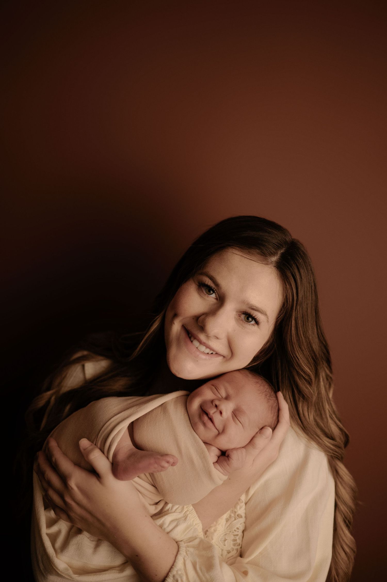 Studio portrait showing tender embraces against a warm brown background.