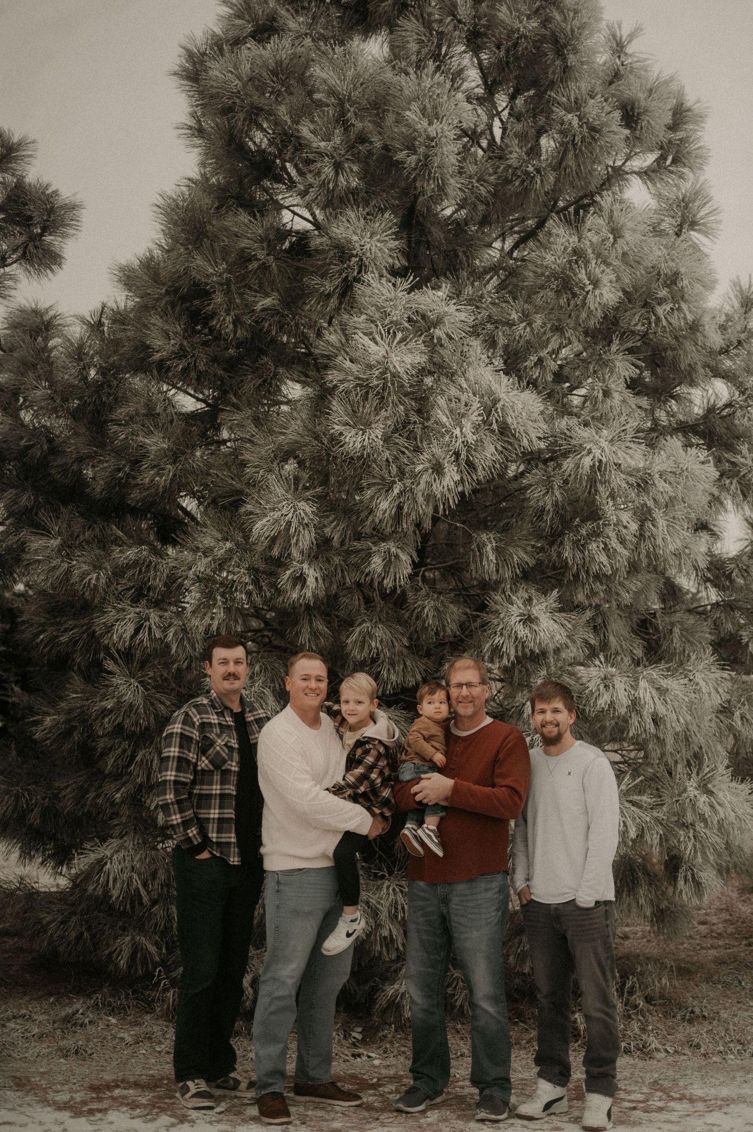 Group photo session in front of a large pine tree with a vintage sepia tone filter.