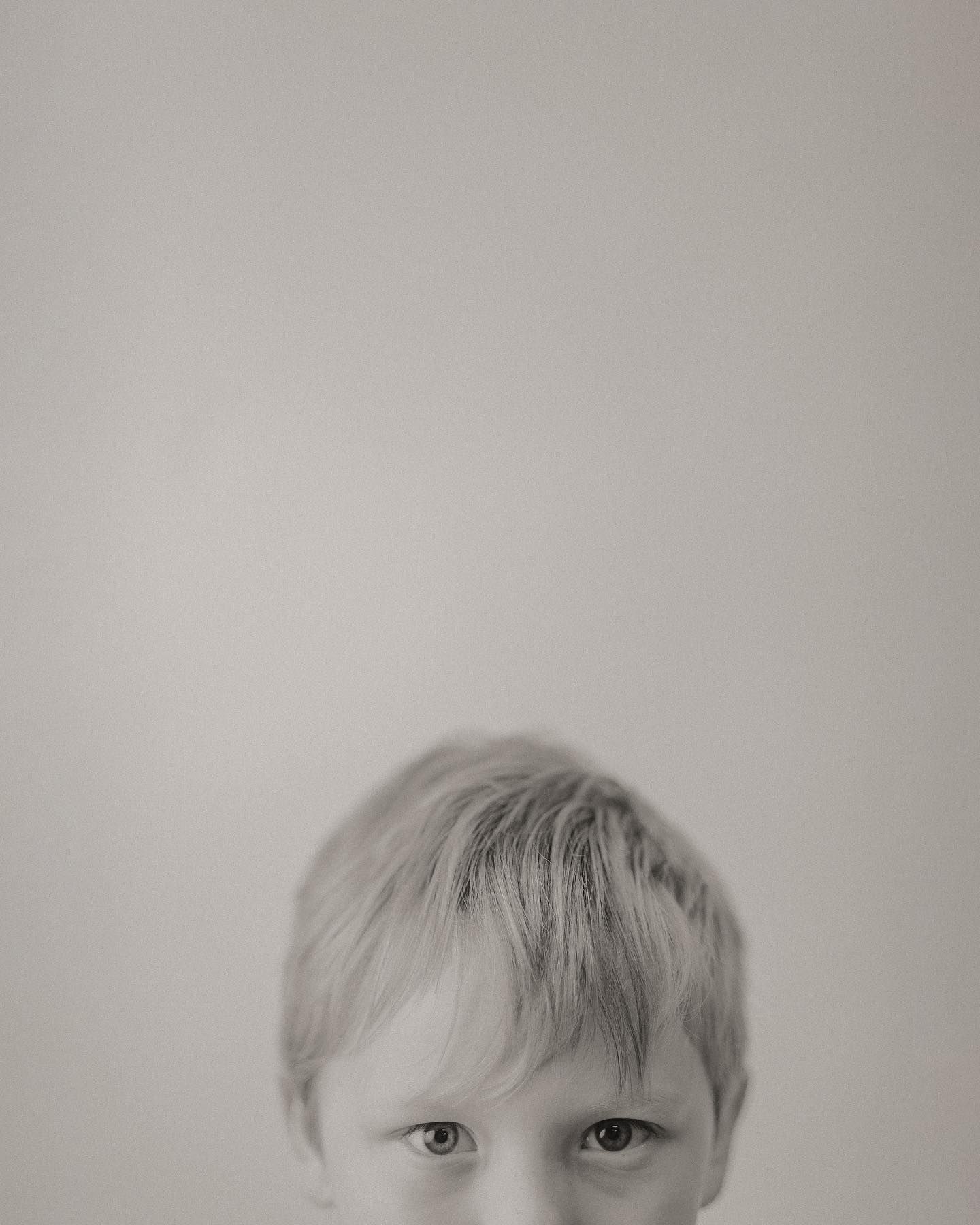 A series of four black and white portrait photographs showing different angles and expressions of a child.