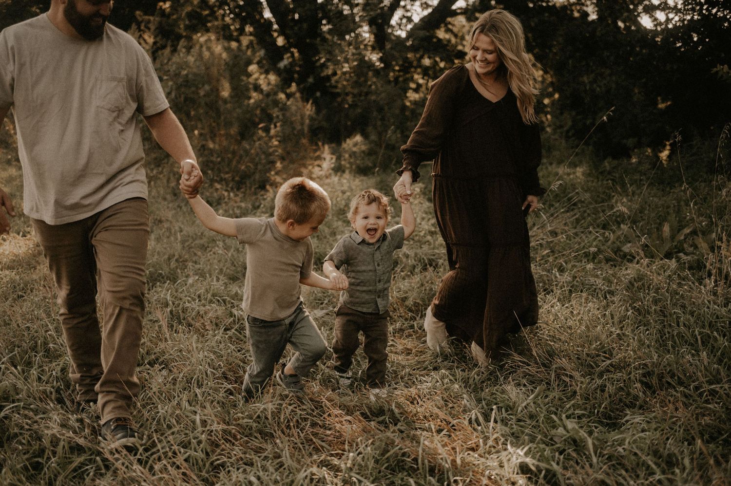 Family playing together in a golden sunset field.
