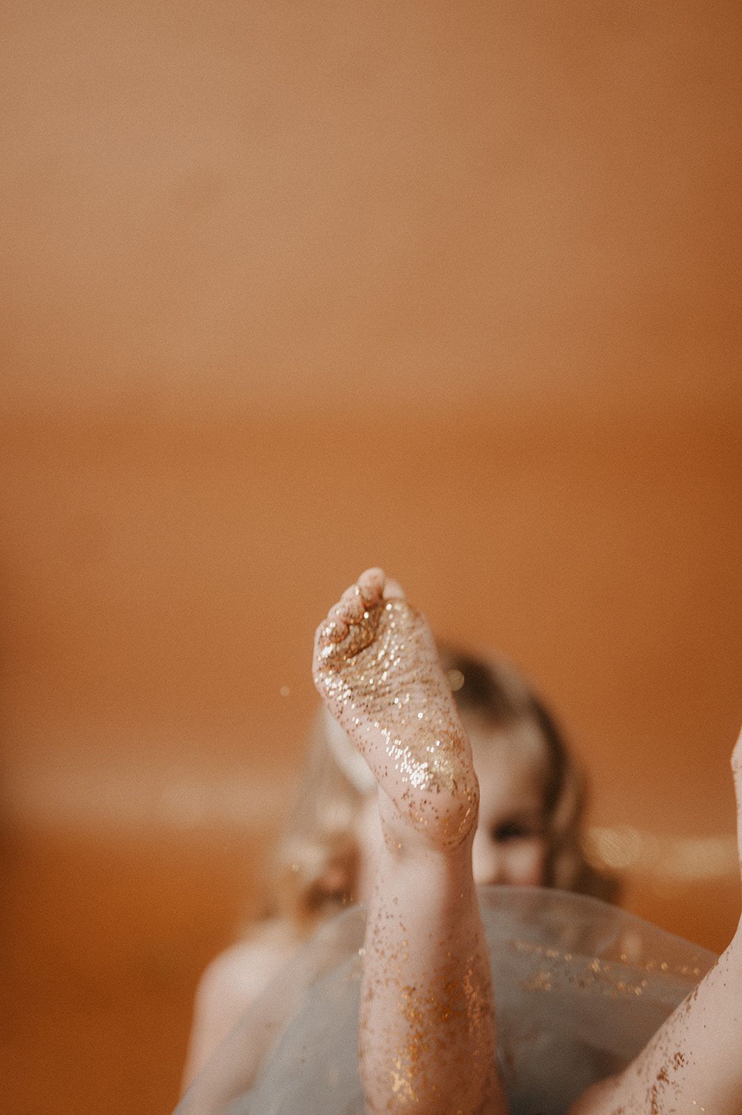 Close-up macro photograph of a gecko's toe showing detailed texture and adhesive pads in warm brown tones.