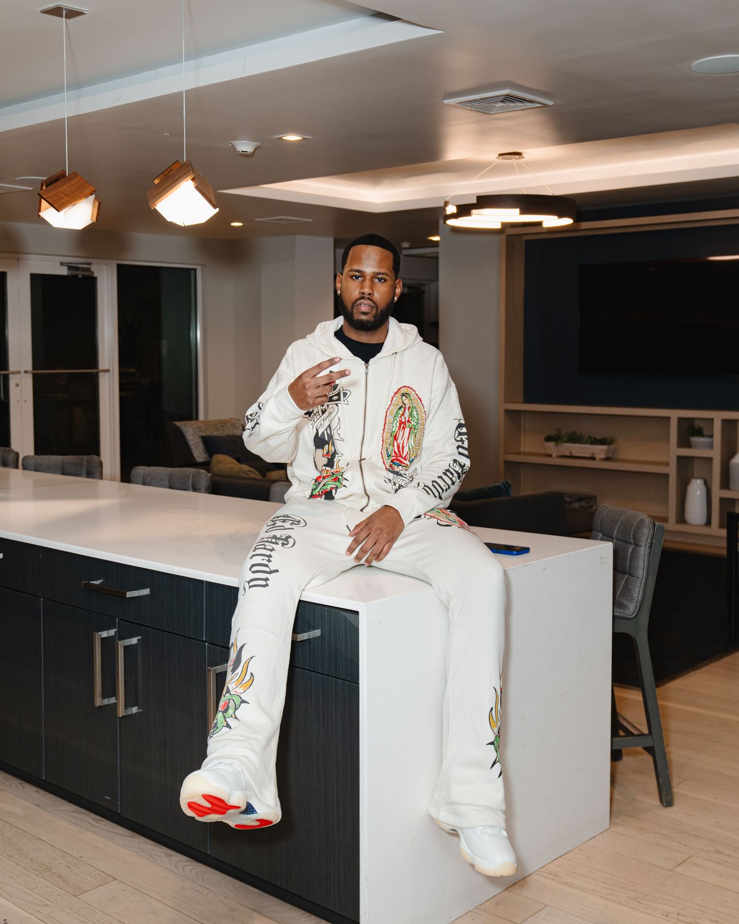 Person in decorative white outfit strikes poses against modern interior with black cabinets. Greater Boston Area photographer, Malden MA.