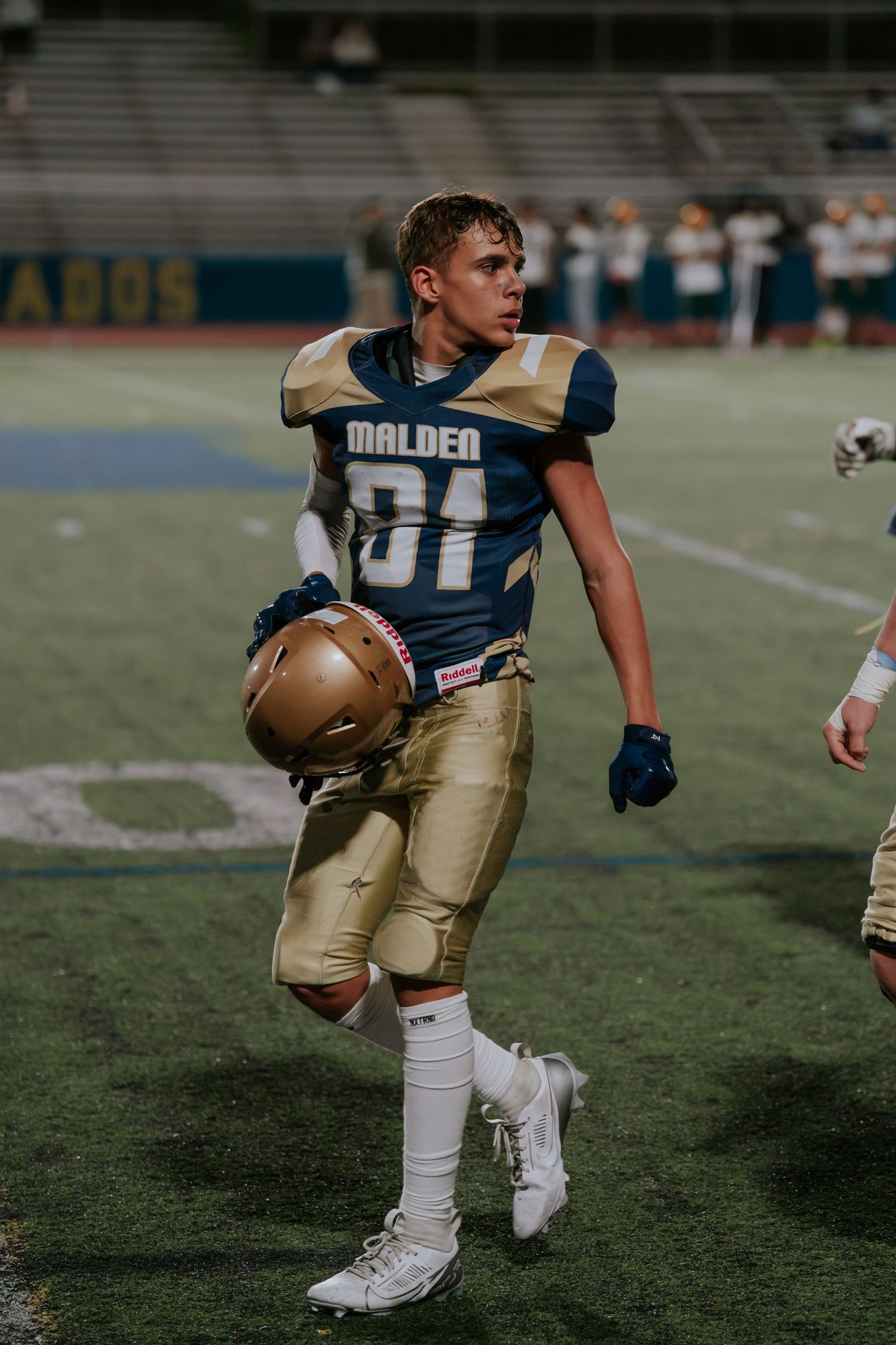 Football player in navy and gold uniform running with ball during game on grass field. Boston MA photographer, Malden MA & Greater Boston.
