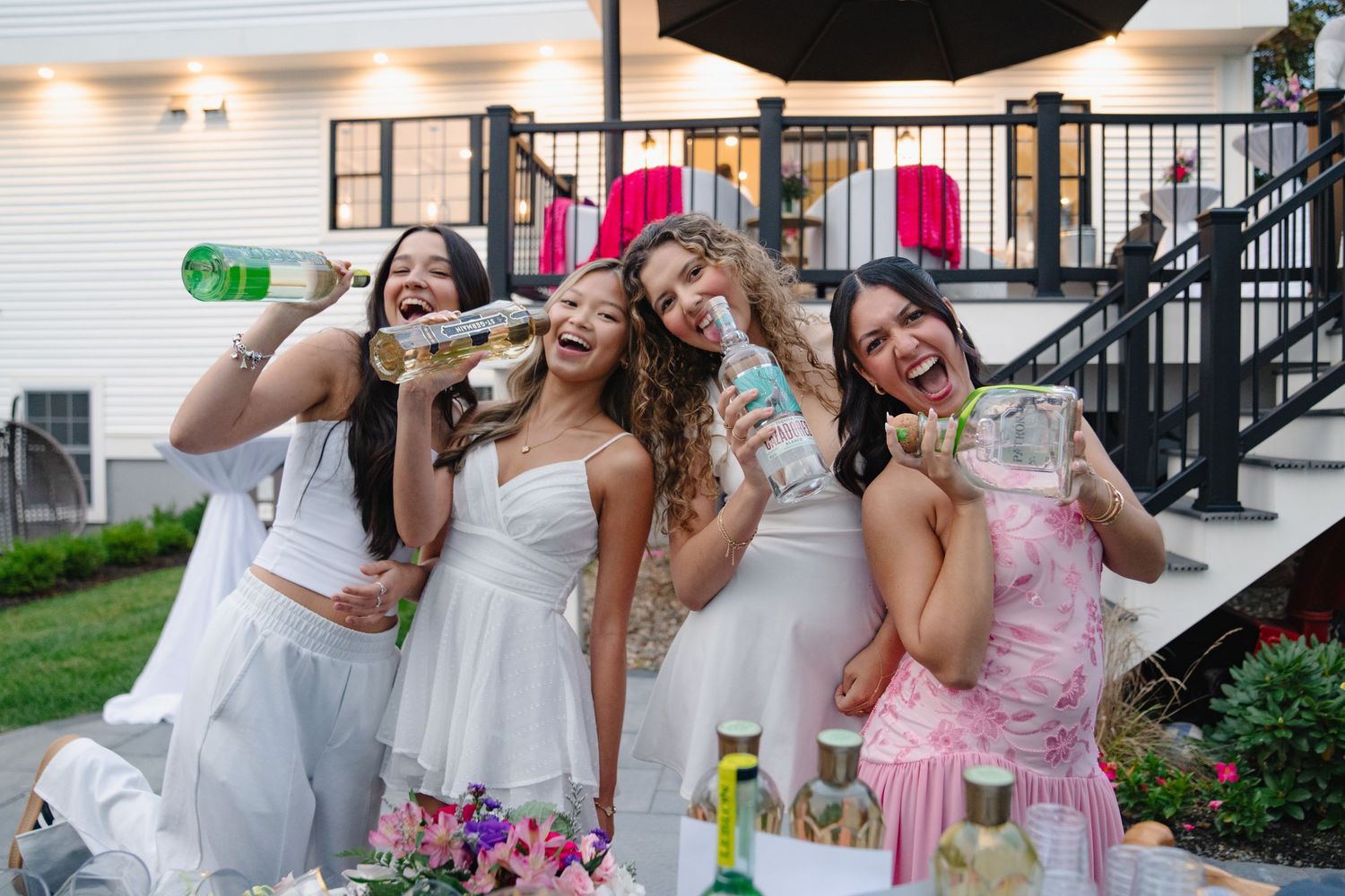Girls toasting with champagne bottles and glasses on outdoor patio. Boston MA photographer, Malden MA and Greater Boston.