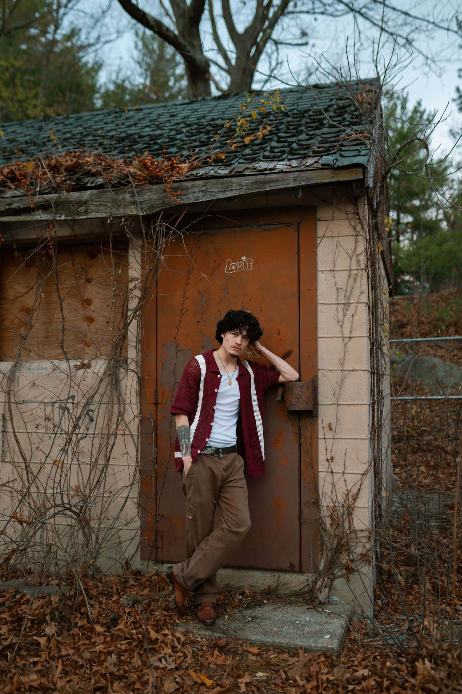 Moody autumn photoshoot by abandoned building with brown door and fallen leaves. Boston MA photographer, Malden MA and Greater Boston Area.