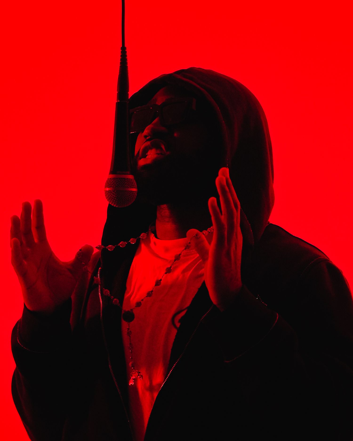 Silhouetted figures against a bright red background creating a dramatic and mysterious atmosphere. Boston MA photographer, Malden MA.
