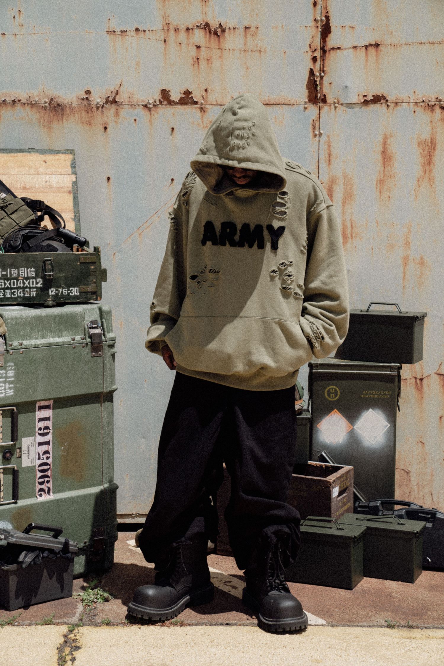 Military-style clothing shown near rusty metal wall with green utility containers. Boston MA photographer, Malden MA & Greater Boston Area.