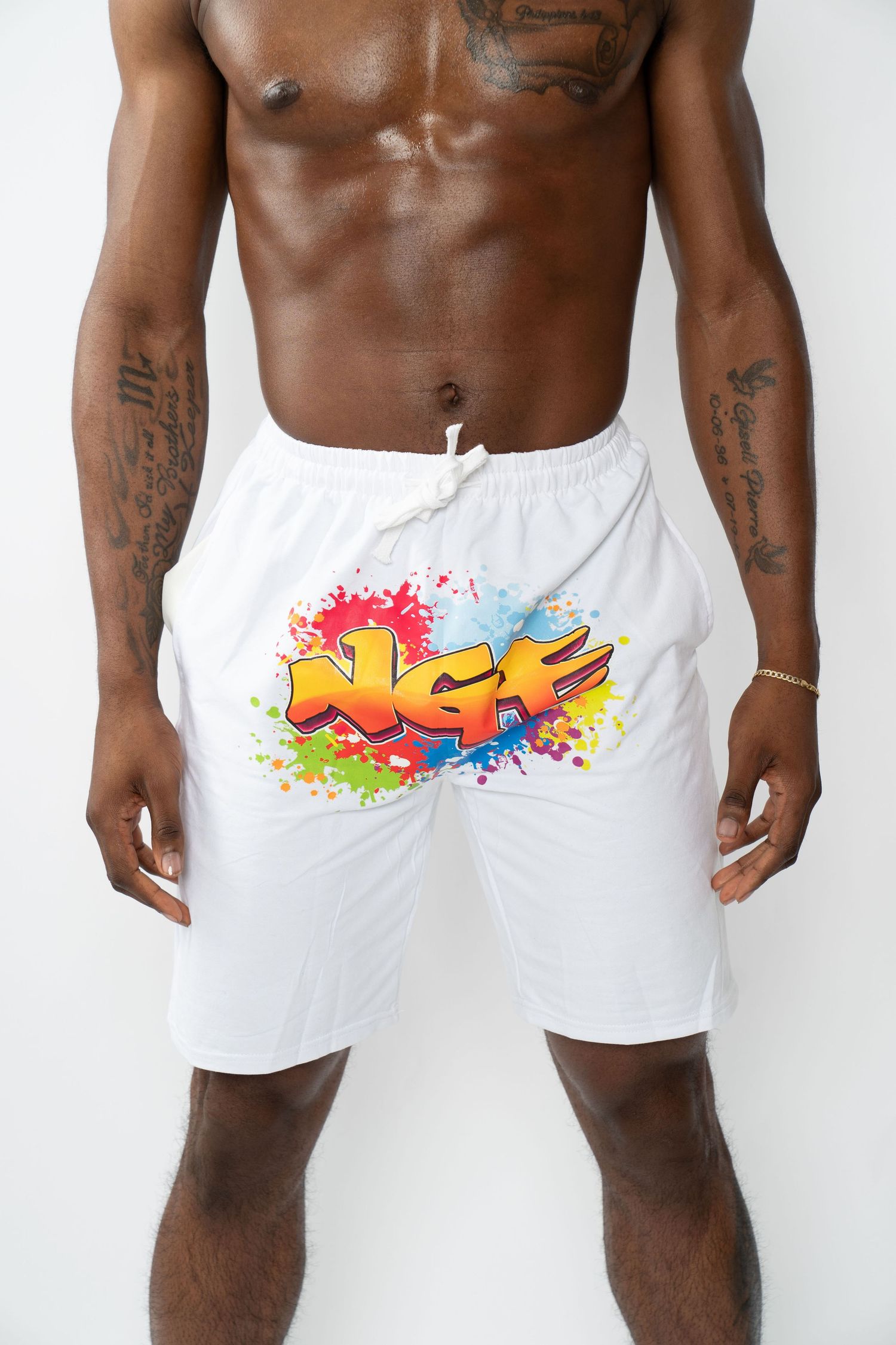 White athletic shorts with colorful graffiti-style art design featuring vibrant splashes of orange, pink and blue paint. Boston photographer