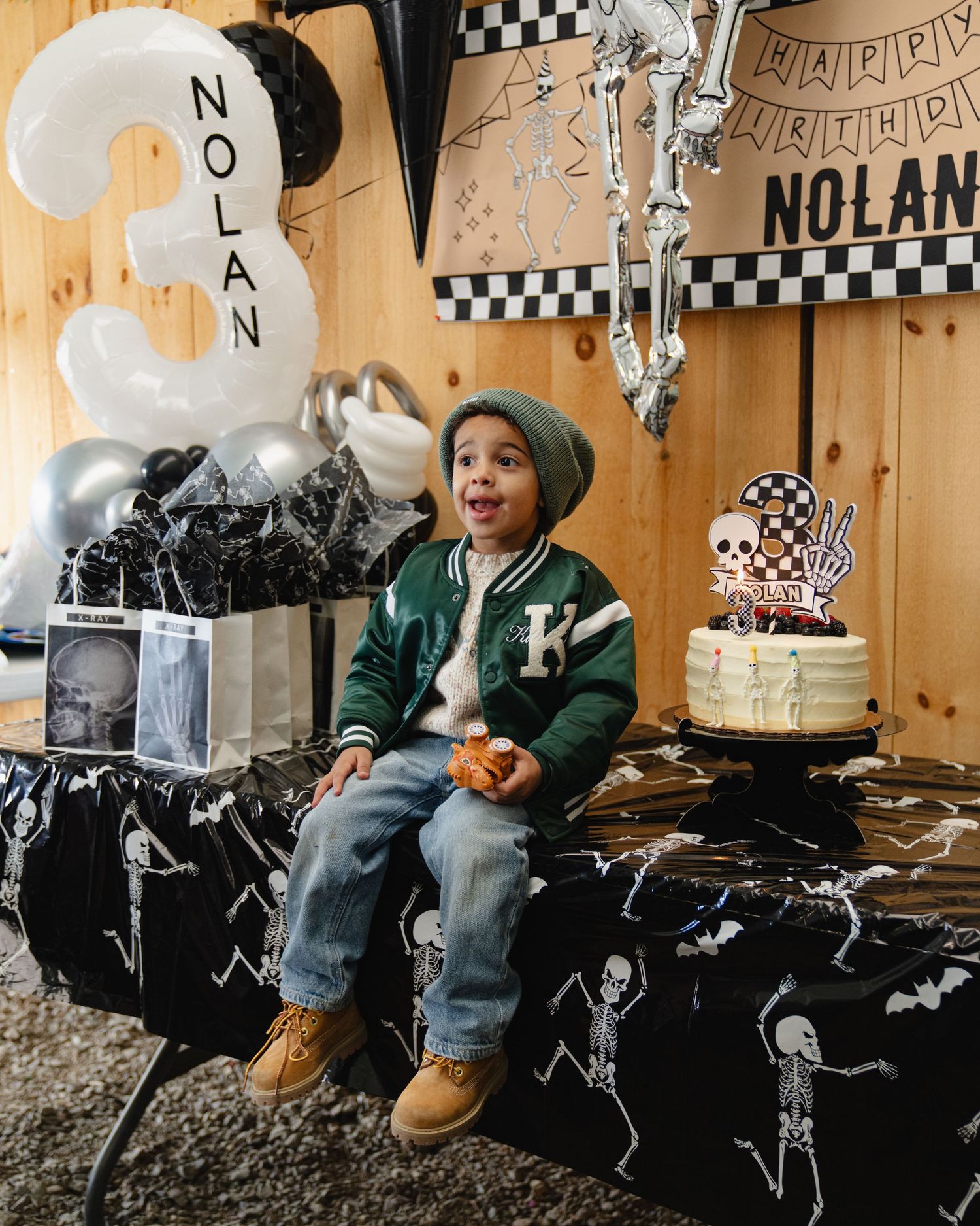 Black and white birthday party decor with a cozy seating area and festive banners on wooden walls. Boston MA photographer, Malden MA.