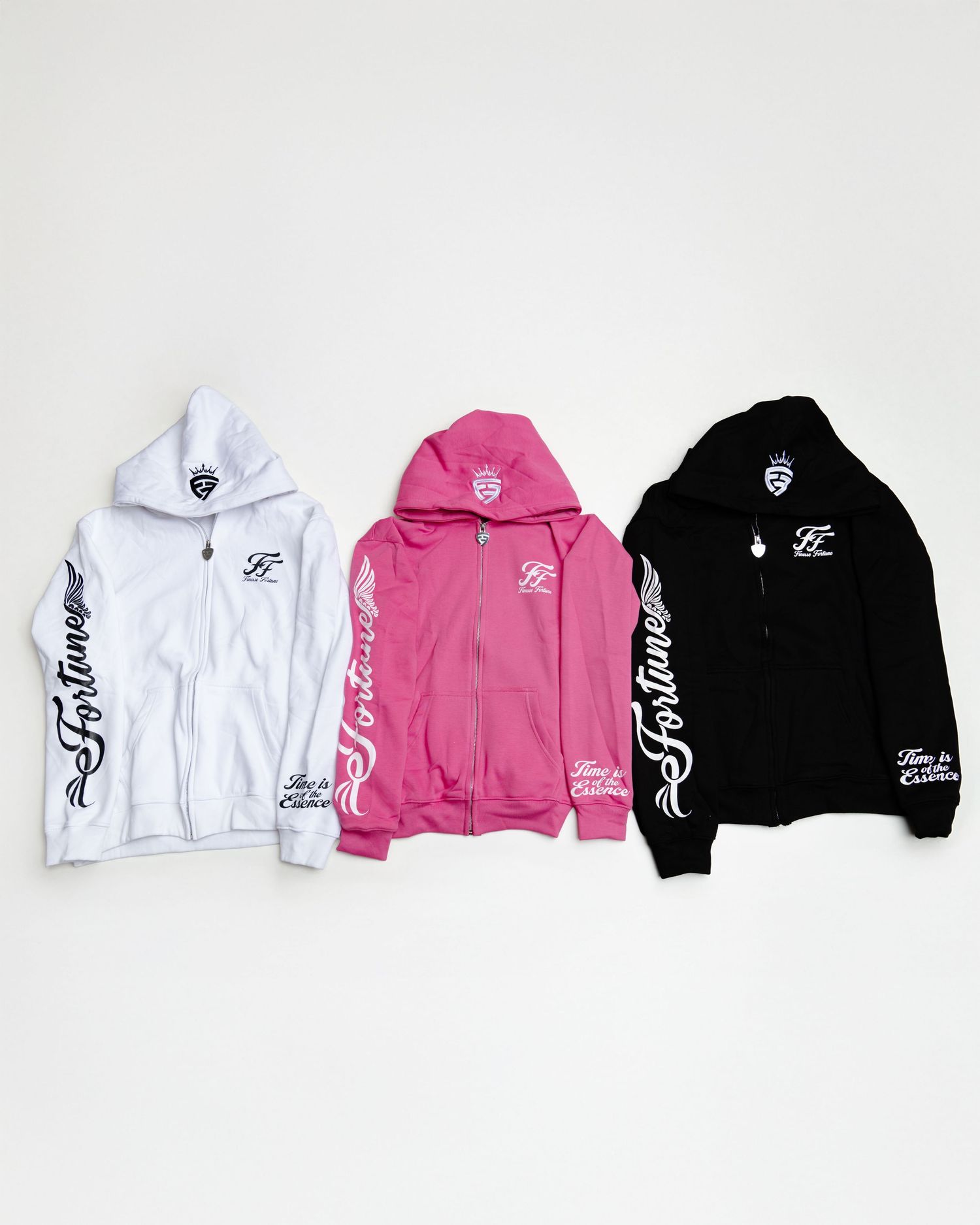 A lineup of hooded sweatshirts displayed in white, pink, and black colors with logo designs on them. Boston MA photographer, Malden MA.