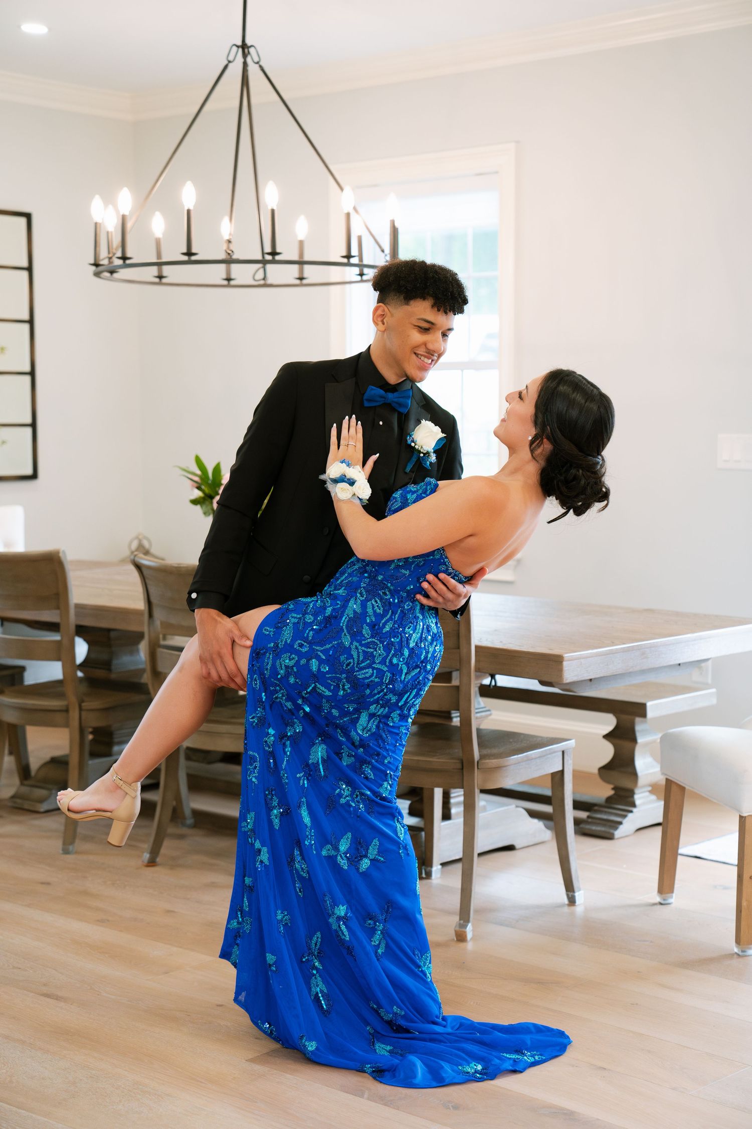 Dancing couple in formal wear, with flowing blue gown, in bright modern interior. Boston MA photographer, Malden MA and Greater Boston Area.
