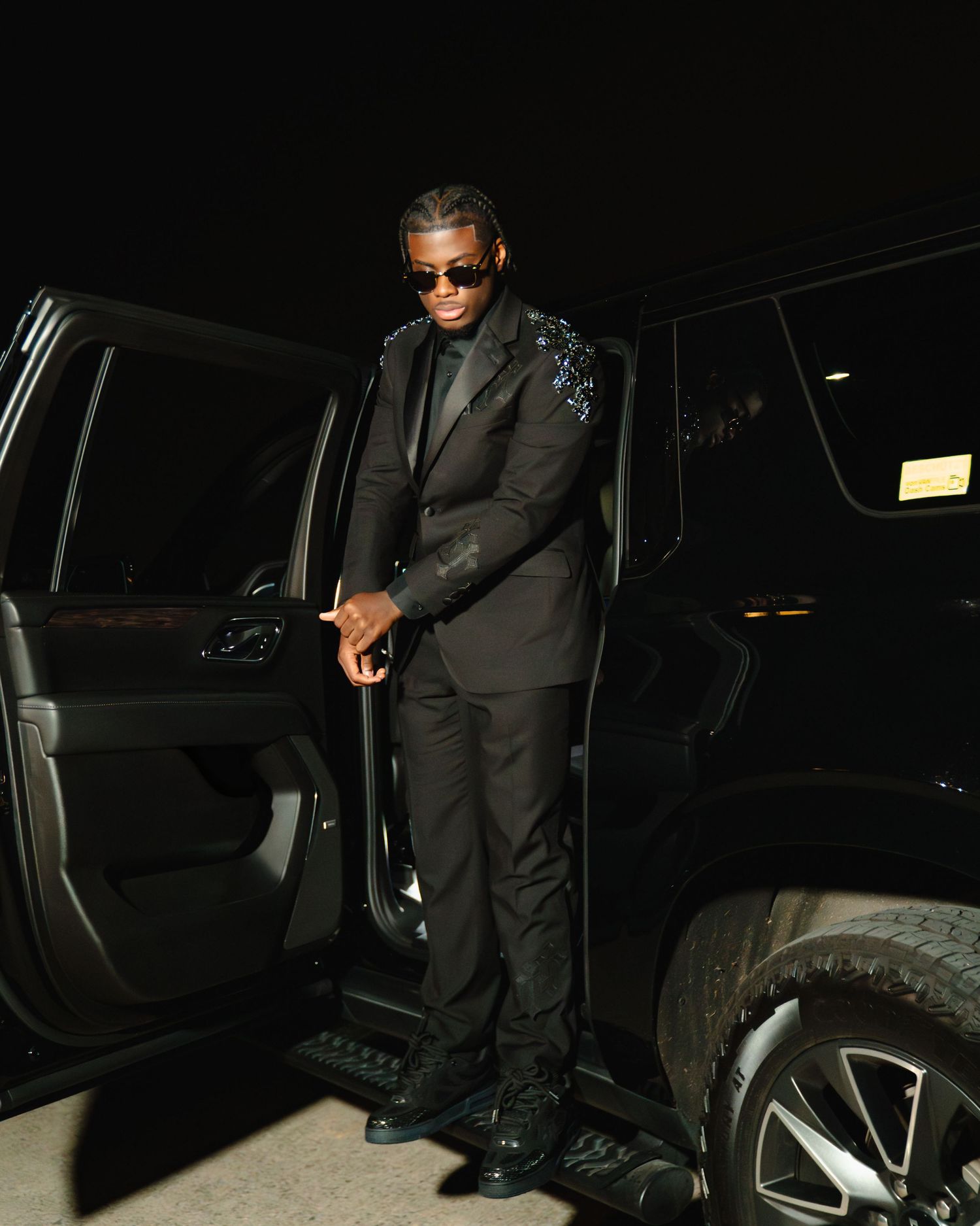 Person in black suit and sunglasses getting into a dark luxury vehicle at night. Boston MA photographer, Malden MA & Greater Boston Area.