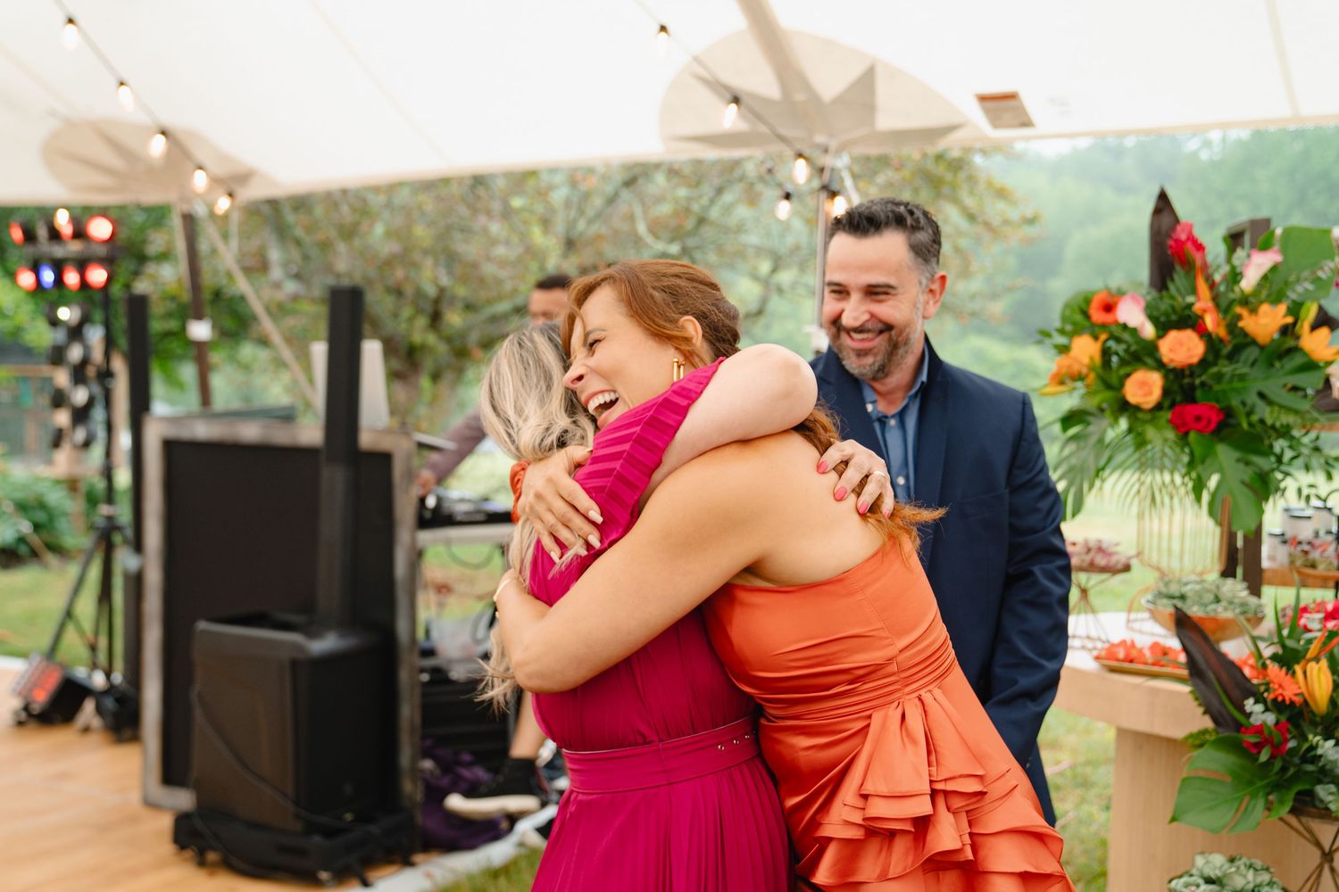 People embracing and celebrating at a birthday with colorful floral decorations and natural scenery. Boston MA photographer, Malden MA.