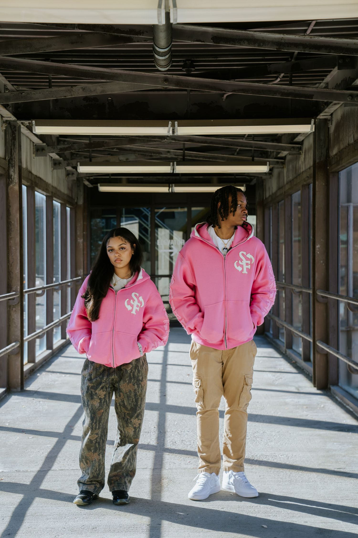 Fashion photography series under covered walkway featuring pink hoodies and casual wear. Greater Boston Area photographer, Malden MA.
