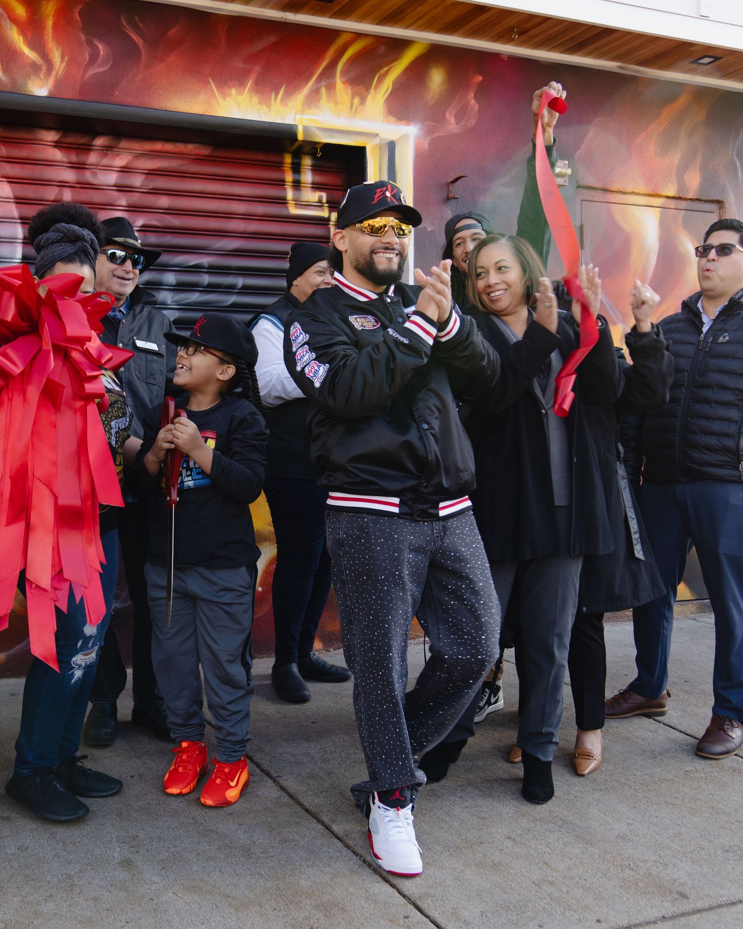 A crowd of people wait in line outside a building with red decorative elements. Boston MA photographer, Malden MA and Greater Boston.