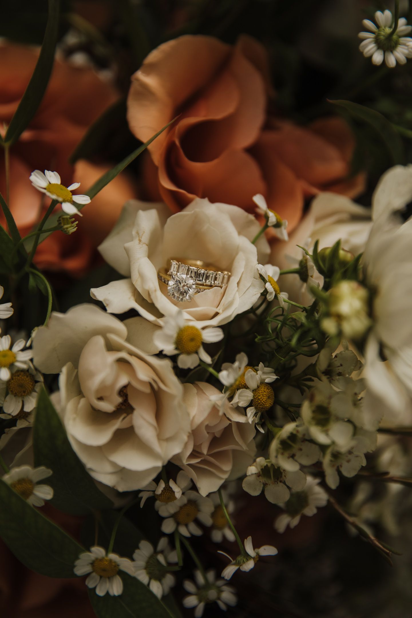 Close-up of delicate white roses and small flowers in a romantic wedding bouquet arrangement.