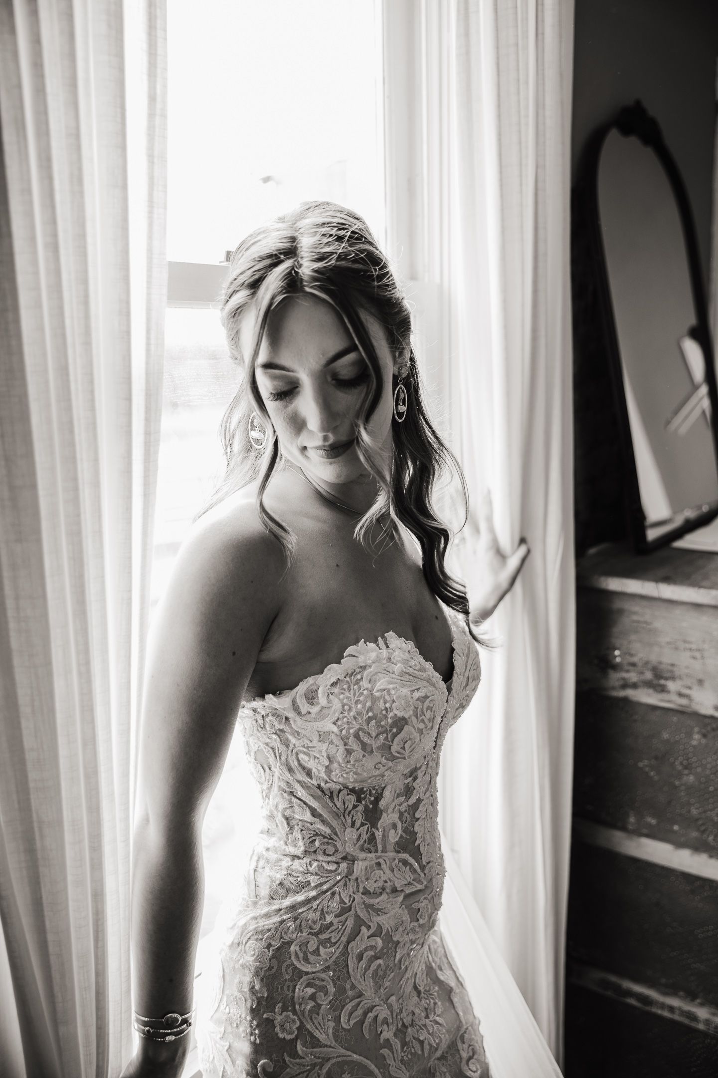 Artistic black and white bridal portraits framed by window light.