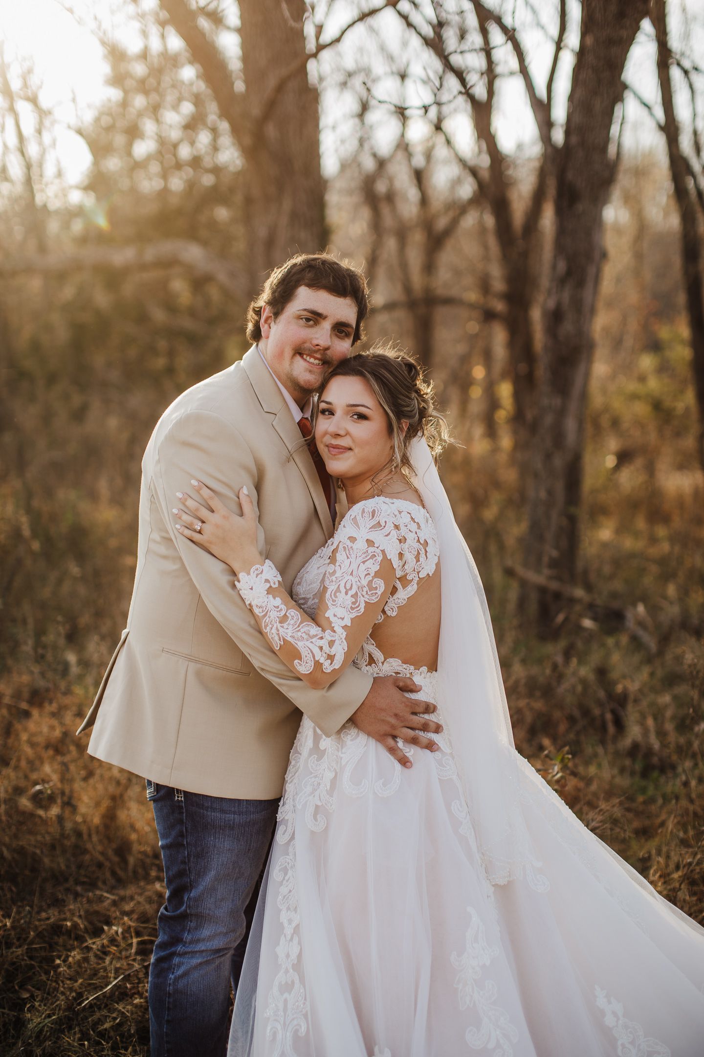 Intimate wedding couple embraces during autumn outdoor photo session.