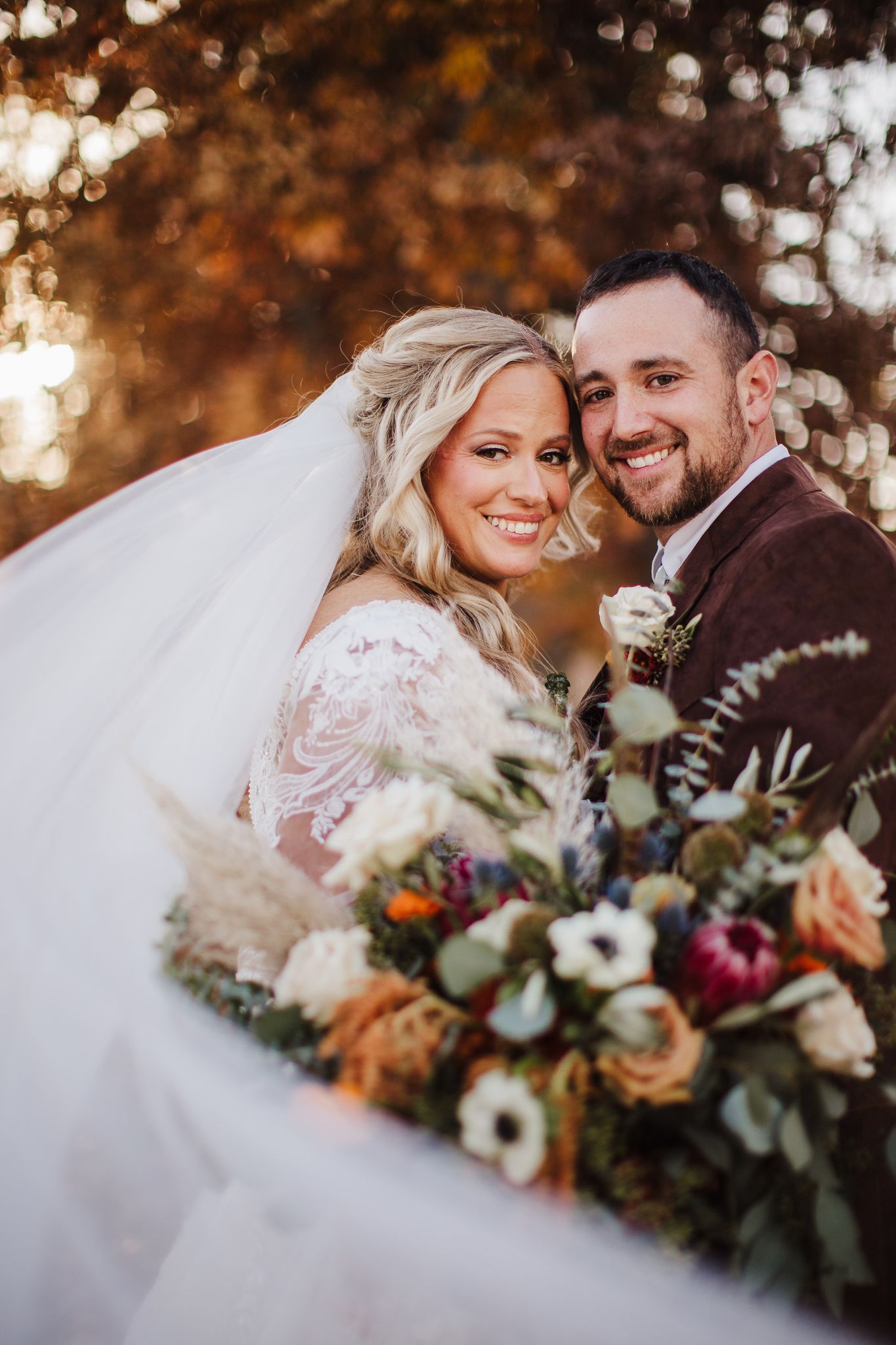 Autumn wedding portrait featuring a beautiful bouquet with burgundy and peach florals.