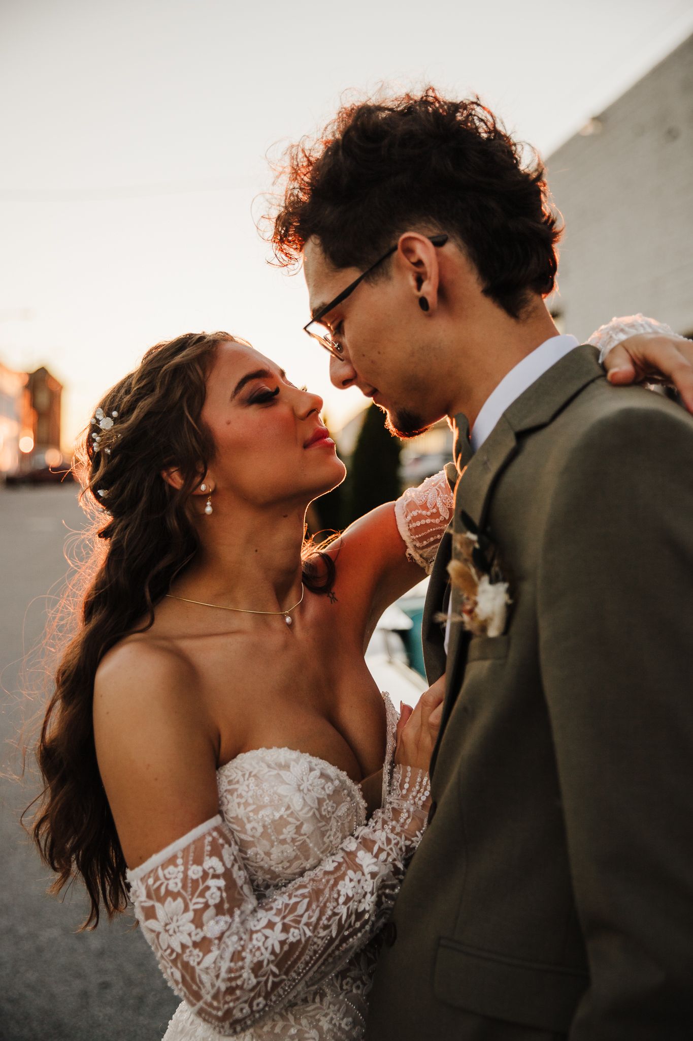 Romantic wedding couple sharing intimate moment in dramatic sunset lighting.