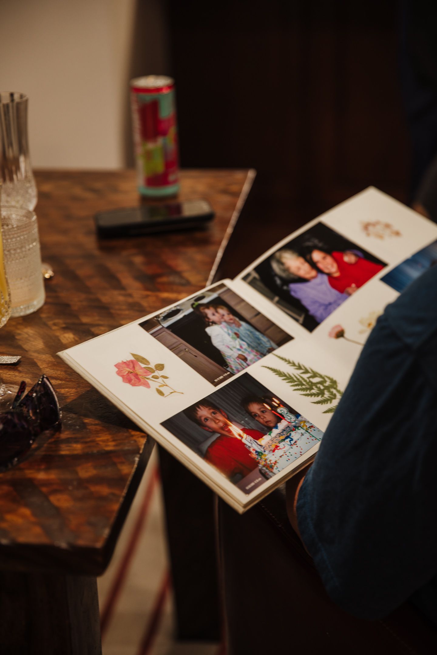 Multiple photographs spread out on a dark wooden table during a review session.