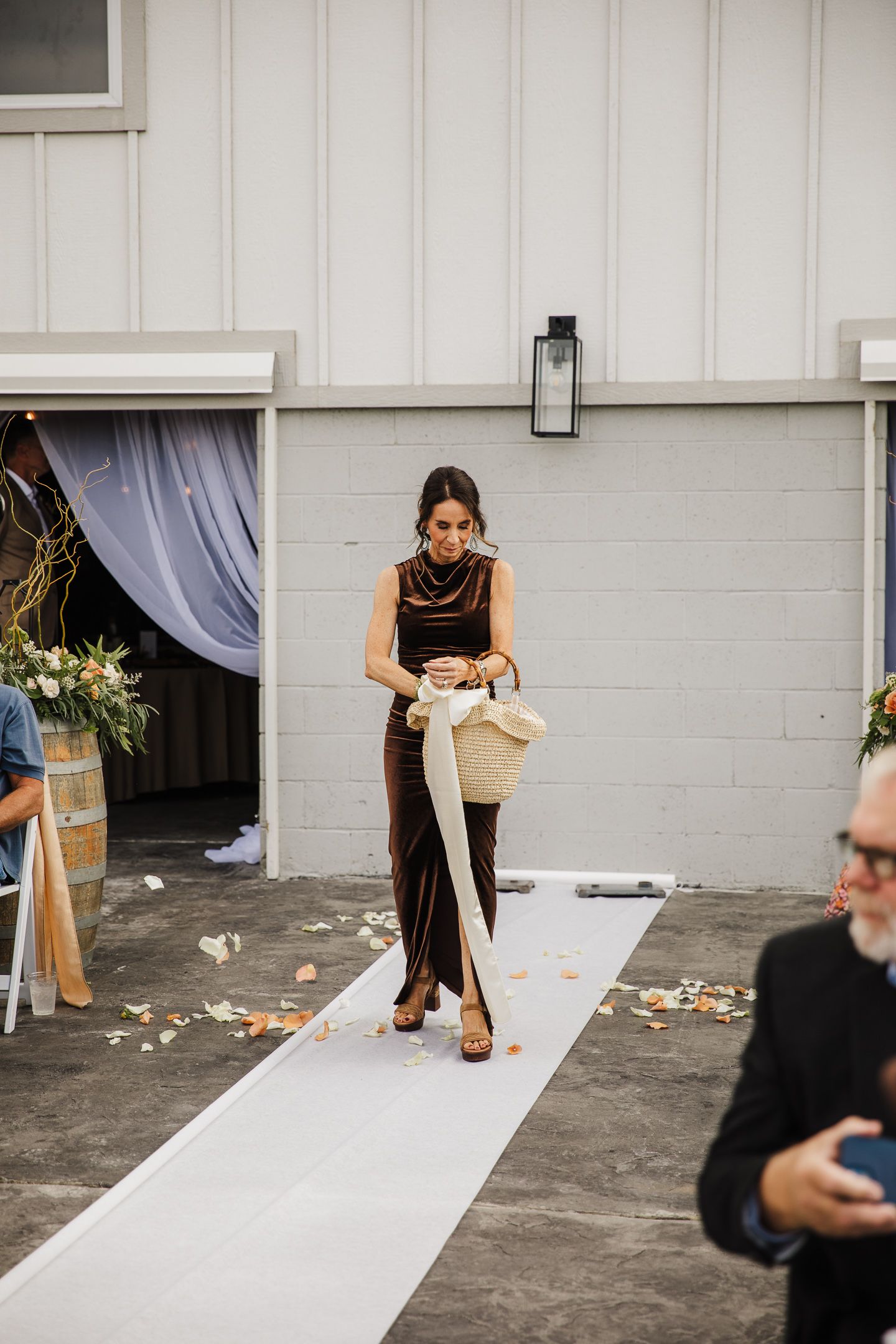 Wedding venue setup showing a white aisle runner being prepared indoors.