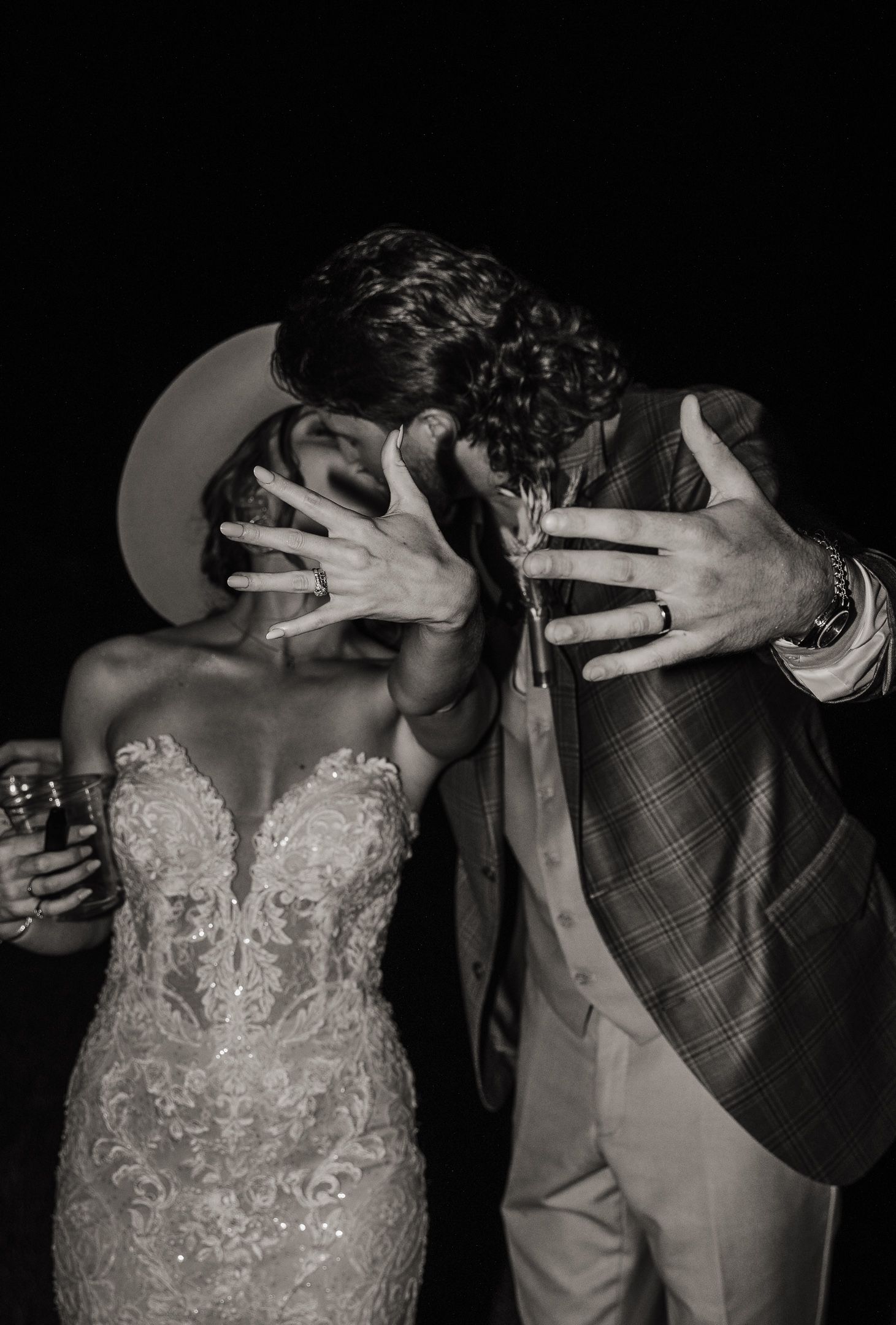 An artistic black and white photo captures an intimate moment between newlyweds.