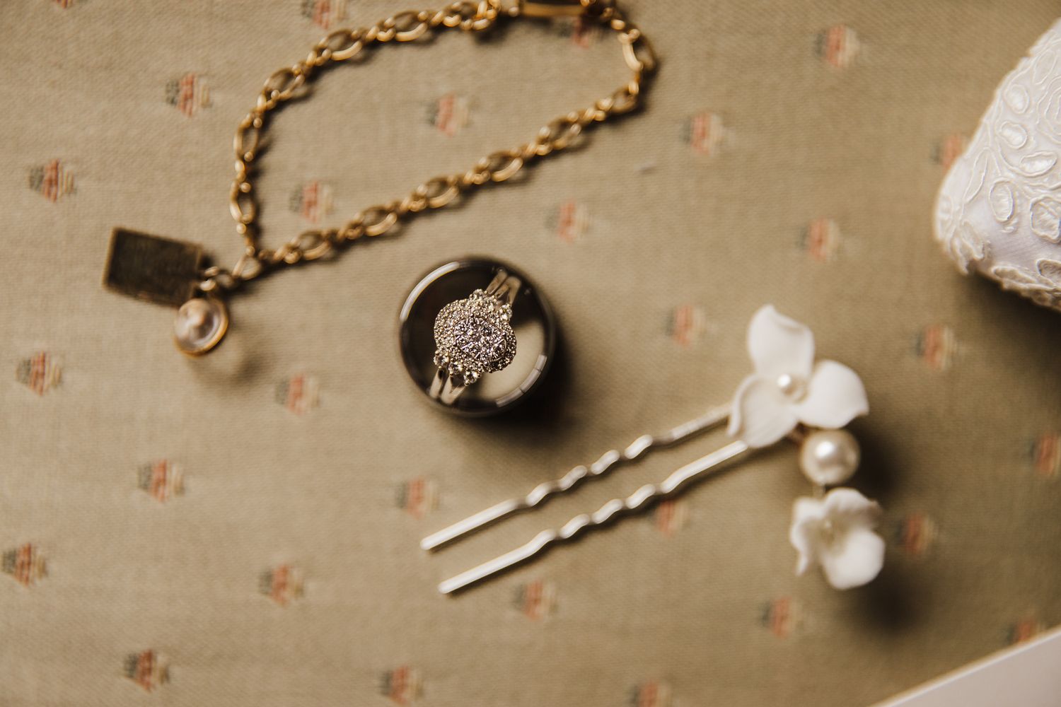 Vintage-style photo of wedding jewelry and accessories on textured background.