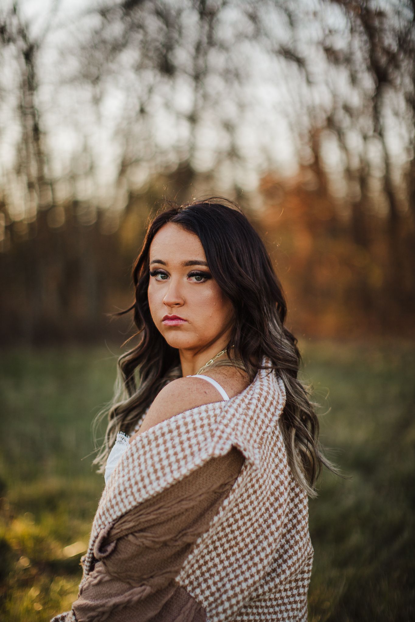 An autumn outdoor portrait featuring a checkered wrap and warm sunset lighting.