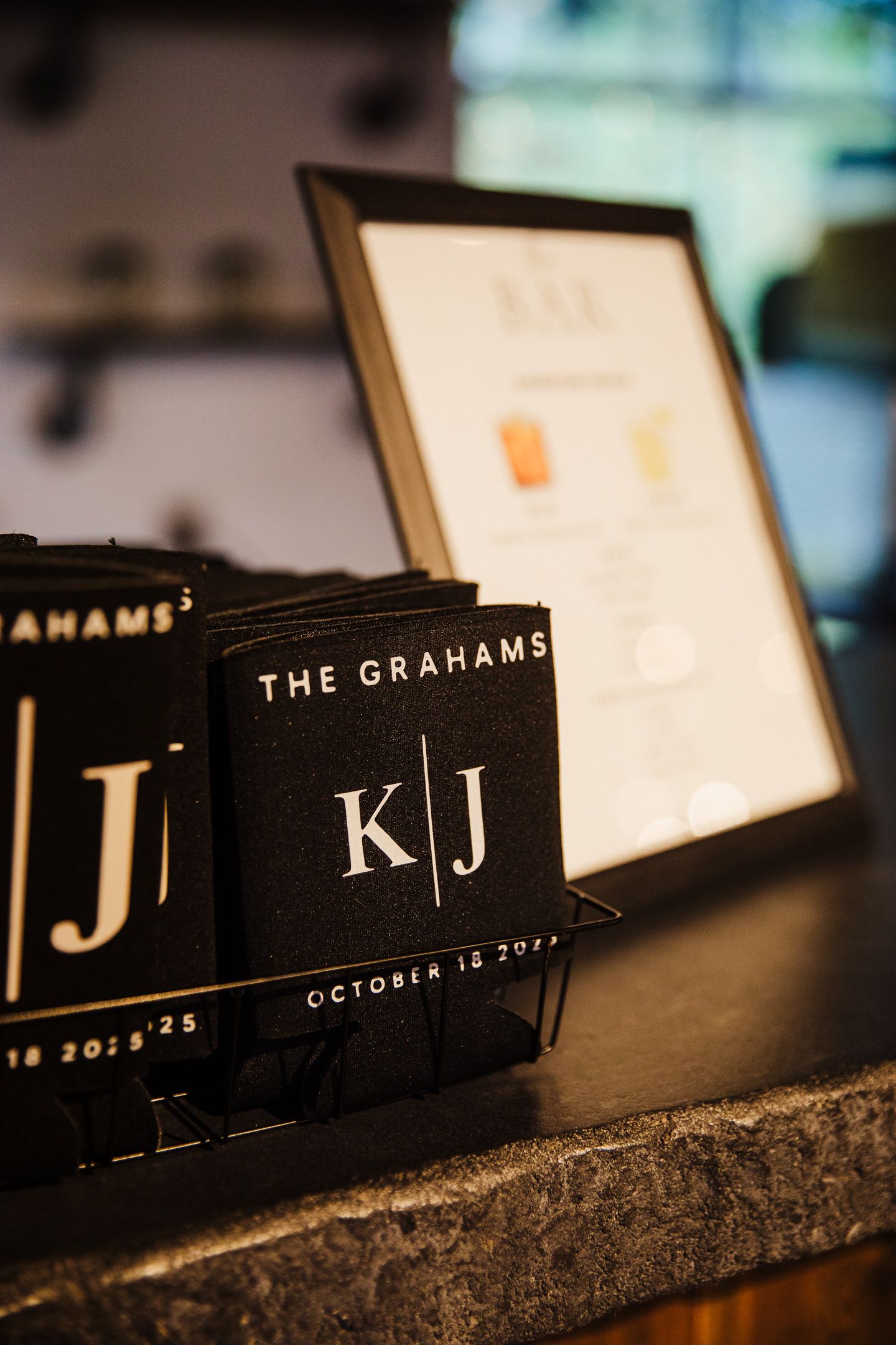 Black wedding place cards with white text arranged in a row showing monogram initials.