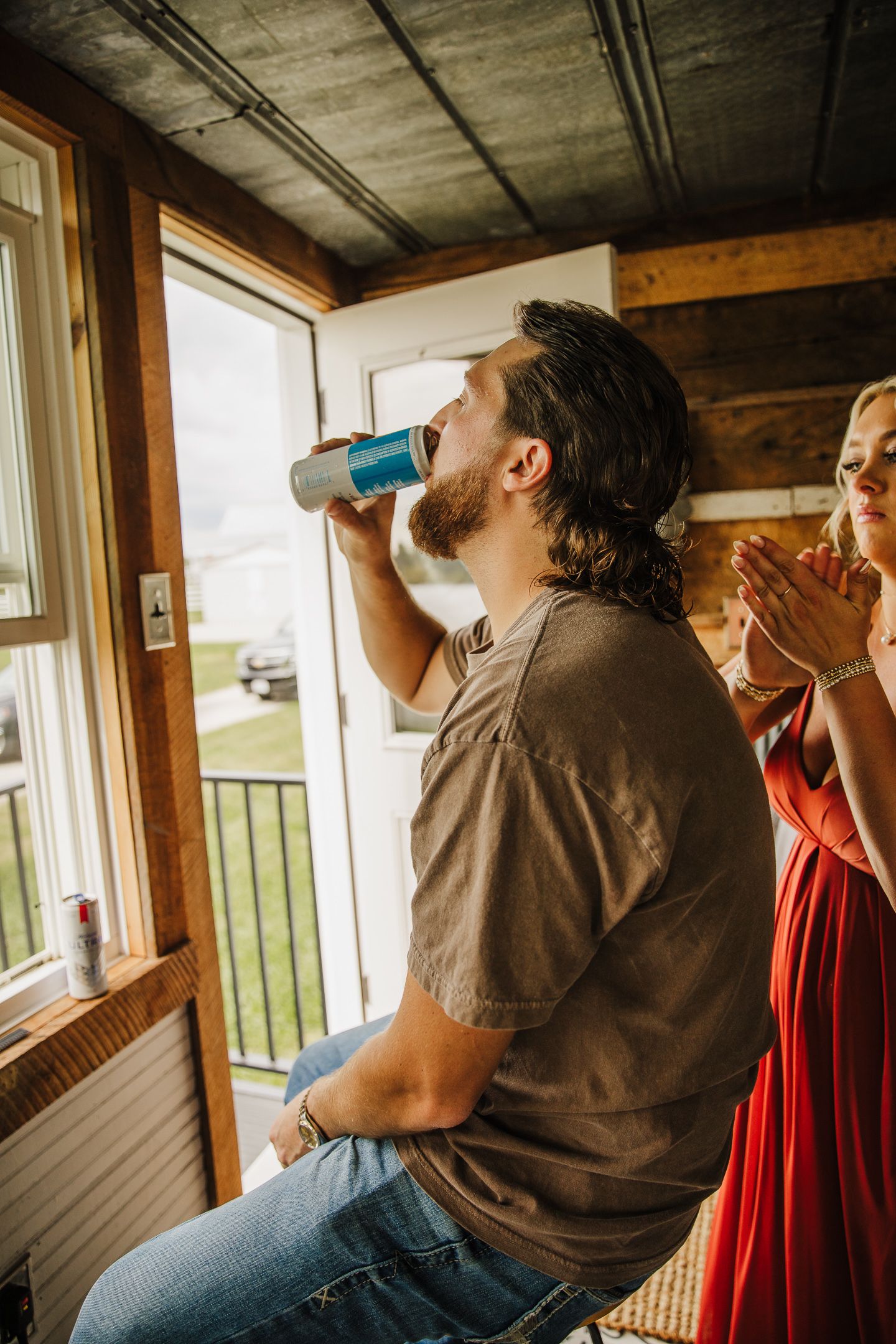 Group gathered on a wooden porch drinking and socializing.