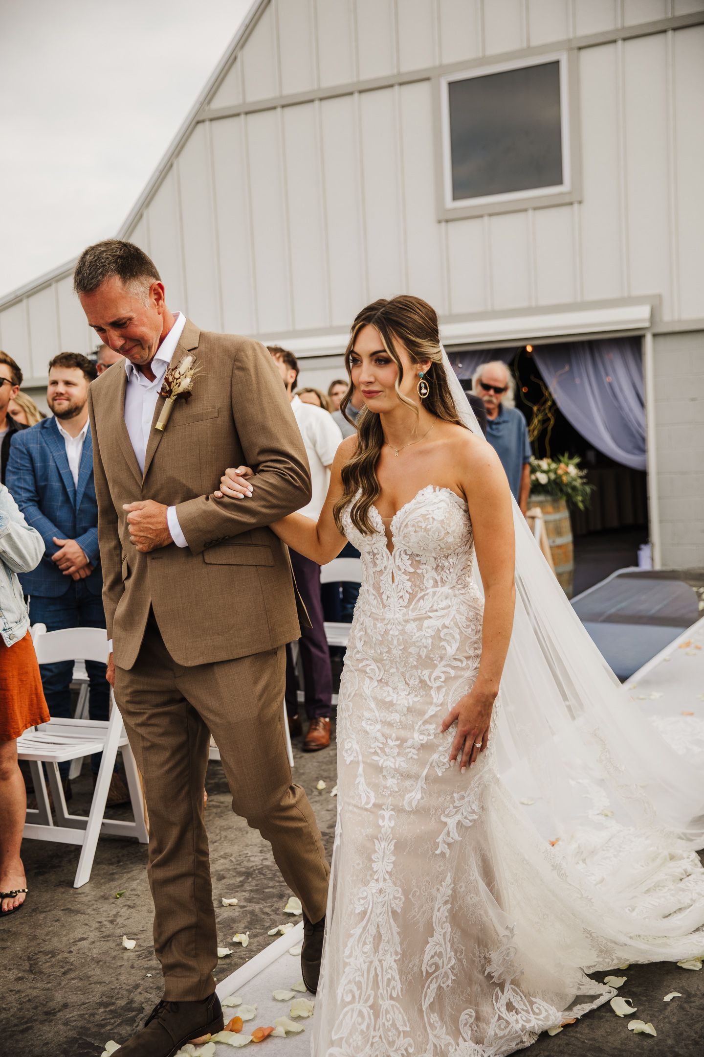 Wedding couple shares intimate moments during reception outside white barn venue.