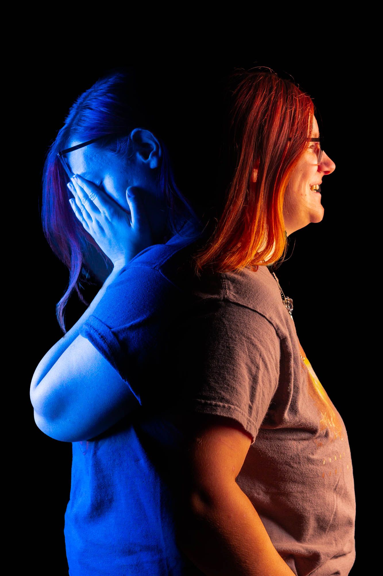 Woman photographed back-to-back in blue and warm light showing contrasting emotional states of distress and happiness.